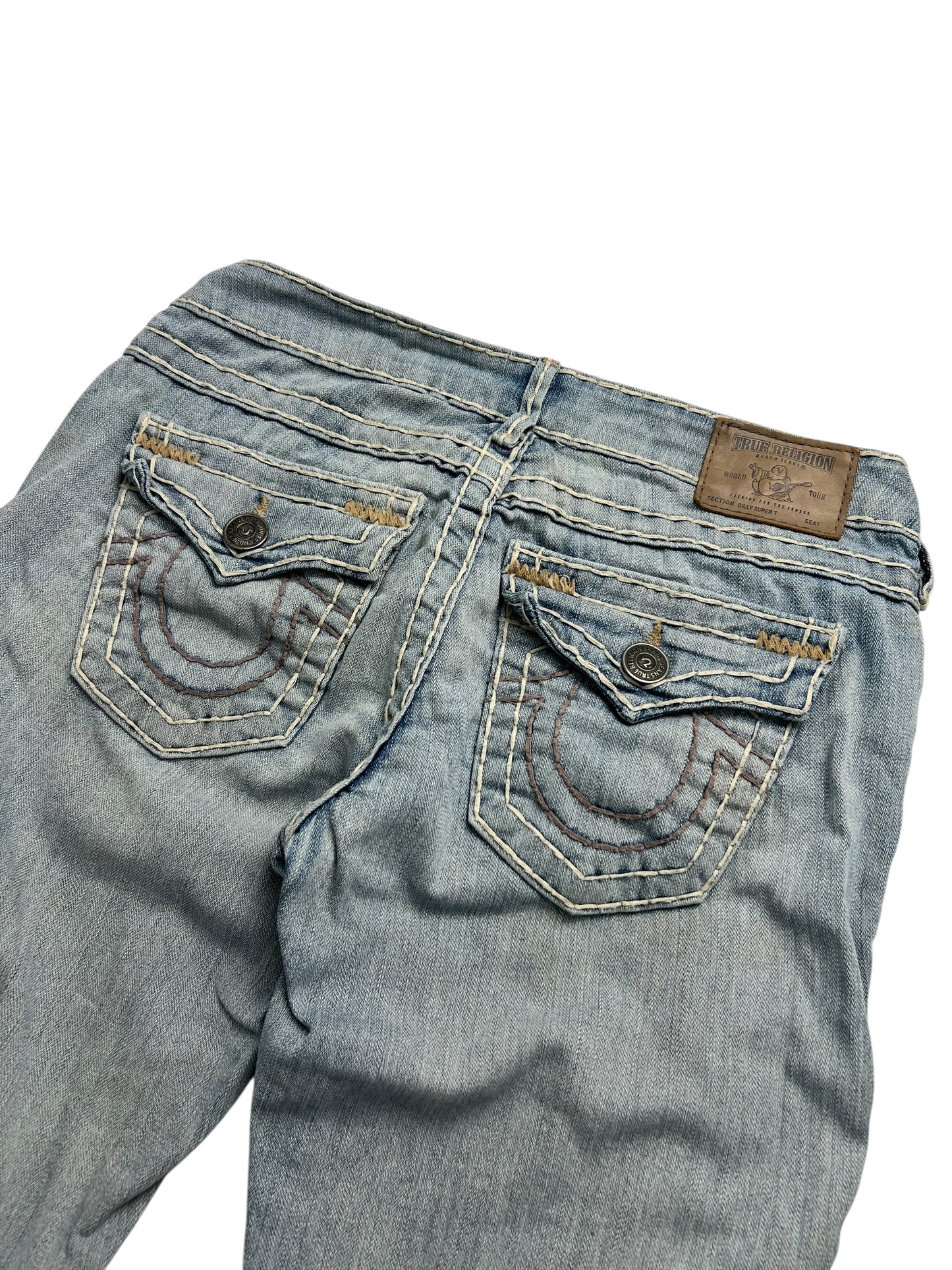 Die von ZAZA weiterverkauften True Religion Billy Super T Low Rise Straight Jeans (W26 x L28) bestehen aus hellblauem Denim, haben Gesäßtaschen mit detaillierten Nähten, Knopfverschlüsse, einen braunen Markenaufnäher aus Leder und eine angegebene Bundweite für mehr Komfort.