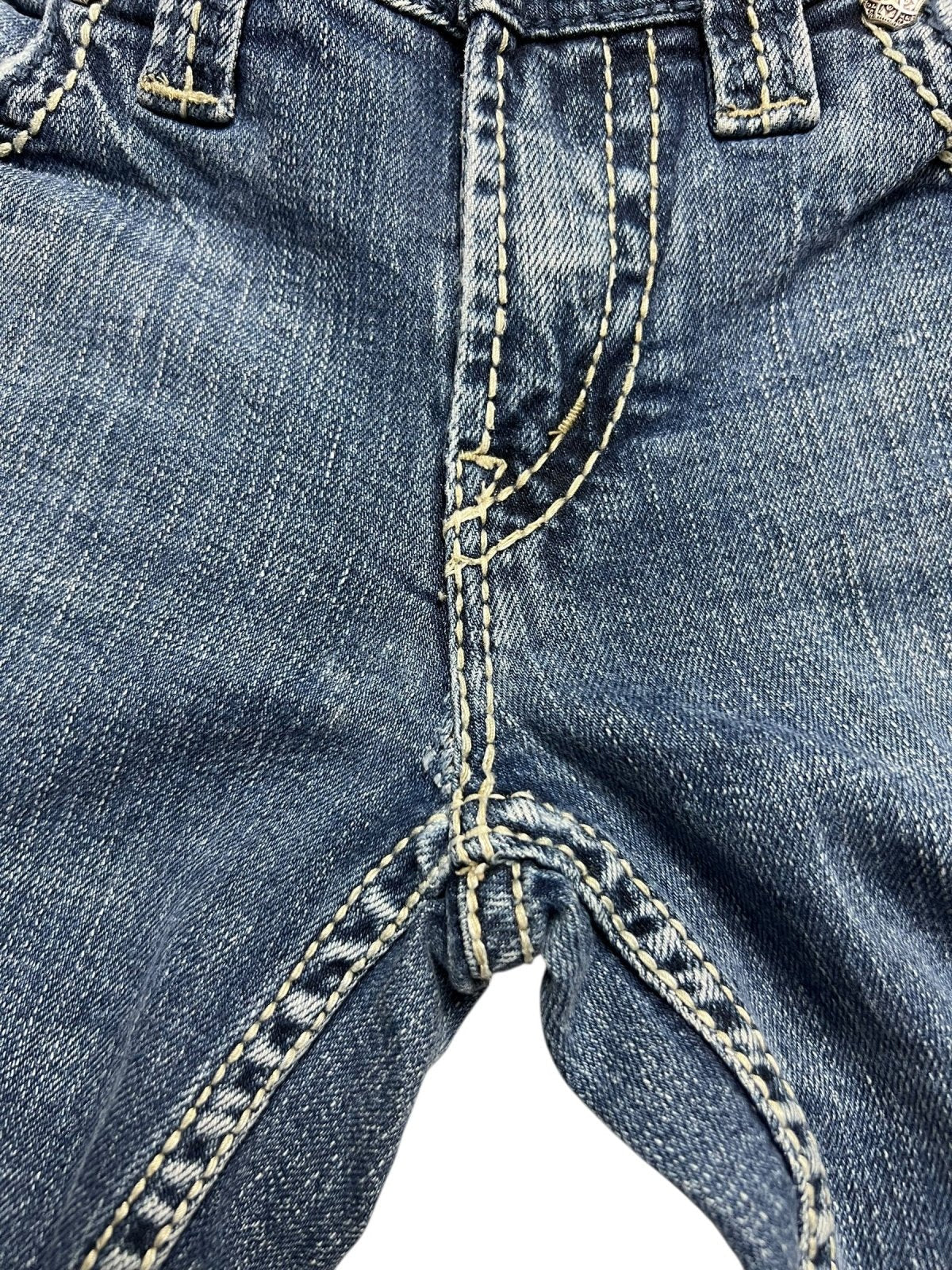 Nahaufnahme der Silver Jeans Low Rise Boot in Größe 29 (M) von ZAZA resell, die den vorderen Schrittbereich mit sichtbaren gelben Nähten und Nähten zeigt und Details wie Bundweite und Labelgröße hervorhebt.