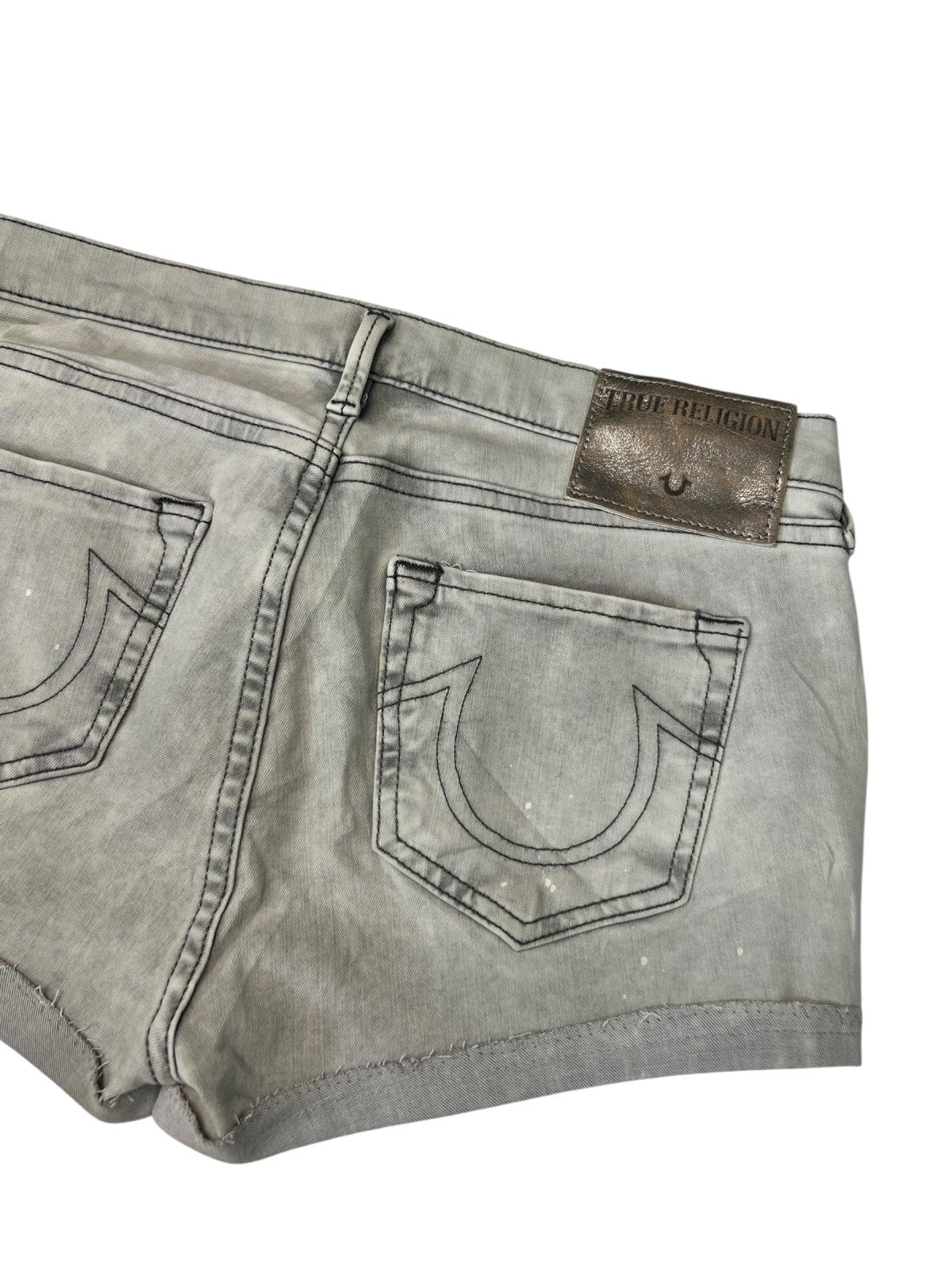 True Religion Shorts | 29 (M) von ZAZA resell: Graue Denim-Shorts mit zwei Rückentaschen, markanter Naht und braunem True Religion Leder-Patch. Der Stoff wirkt leicht getragen und ausgewaschen. Maße in Zentimetern auf Anfrage erhältlich.