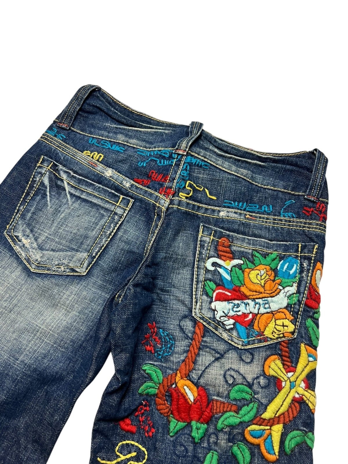 Die Red Pepper Low Rise Boot Jeans von ZAZA resell in Größe 27 (S) besteht aus blauem Denim mit einem verblichenen, abgenutzten Look und weist bunte Stickereien - Blumen, Seile und abstrakte Muster - auf der Gesäßtasche und dem oberen Rückenbereich auf.