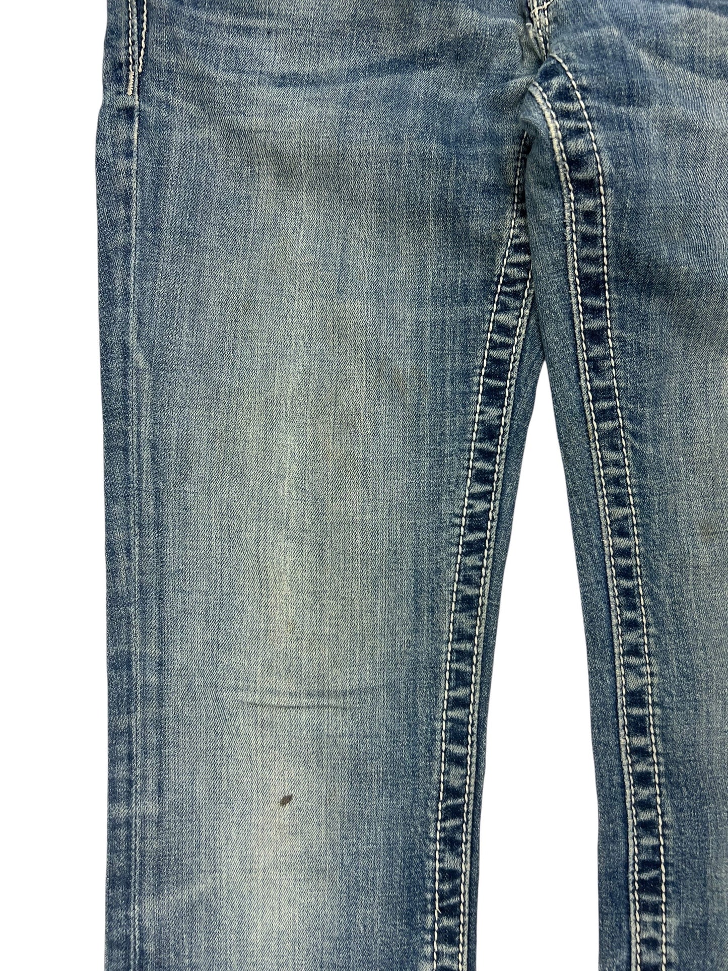 Eine Nahaufnahme der Miss Me Low Rise Straight Jeans von ZAZA resell, Größe 27 (S), aus blauem Denim mit abgenutztem, verblichenem Stoff, sichtbaren Nähten und einem kleinen dunklen Fleck in der Nähe des Knies.