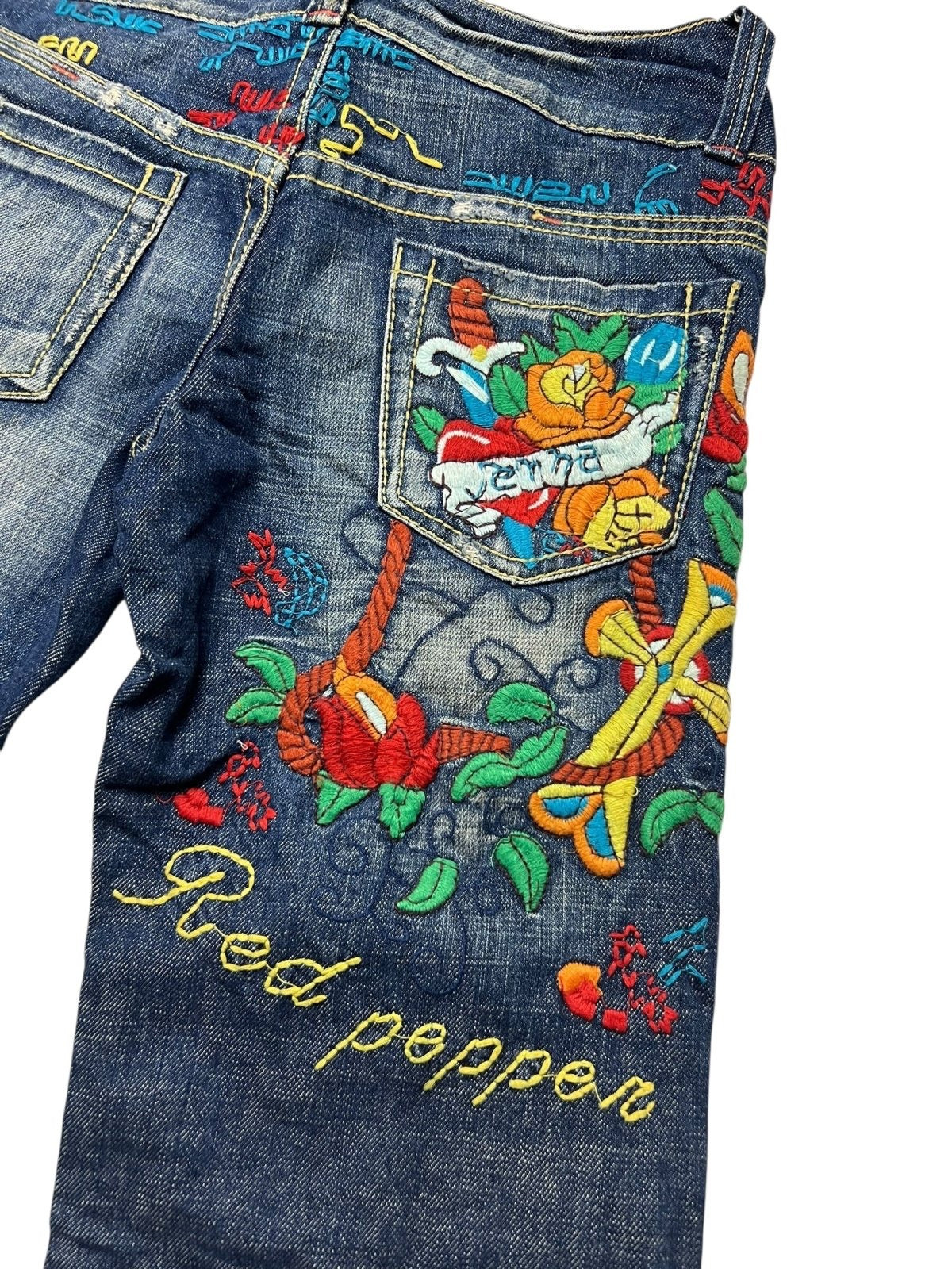 Die blaue Jeans Red Pepper Low Rise Boot | 27 (S) von ZAZA resell zeichnet sich durch farbenfrohe Blumen- und Rankenstickereien aus, mit "Red Pepper" in Gelb auf dem Bein und "Peace" auf der Gesäßtasche für einen einzigartigen, auffälligen Look.