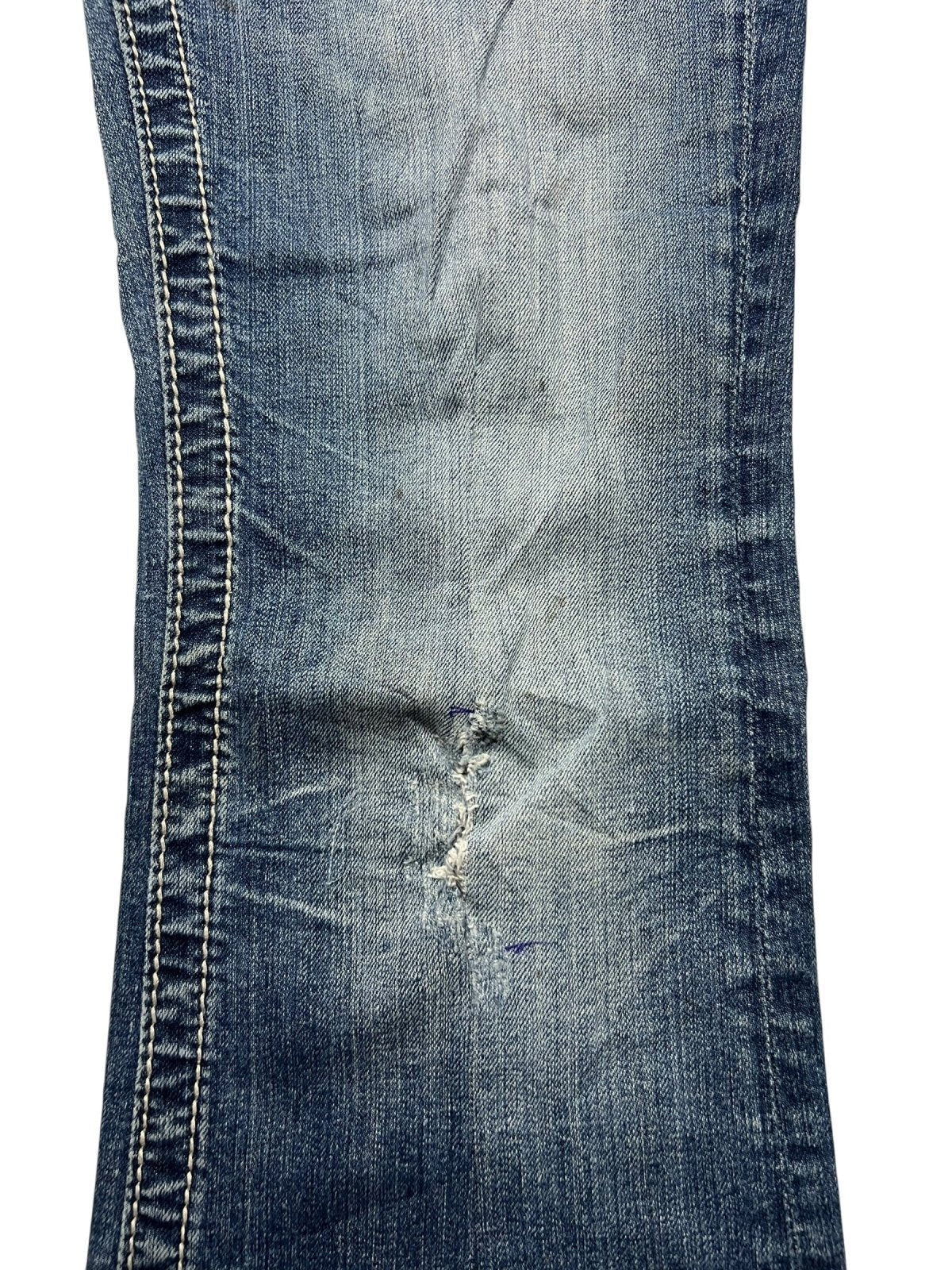 Eine Nahaufnahme der Miss Me Mid Rise Boot Jeans von ZAZA resell zeigt abgenutzten, ausgefransten Denim mit sichtbaren Nahtreparaturen, die den detaillierten Verschleiß sowohl in Bundweite (30) als auch in Labelgröße (M) hervorheben.