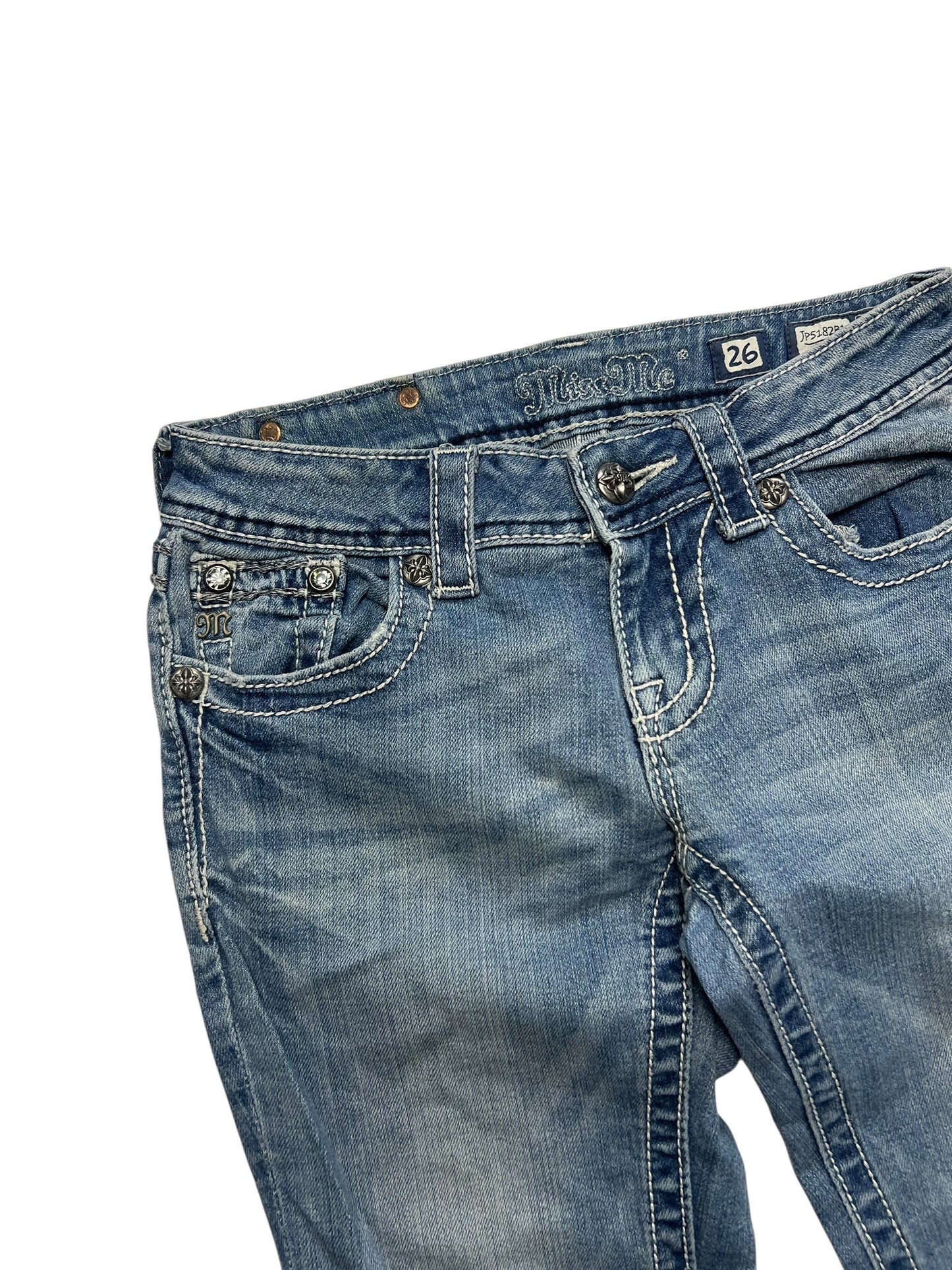 Ein Paar Miss Me Low Rise Boot Jeans in Größe 26 (S) von ZAZA resell mit blauem Denim, weißen Nähten und dekorativen Taschen auf der Vorderseite, abgebildet auf weißem Hintergrund.