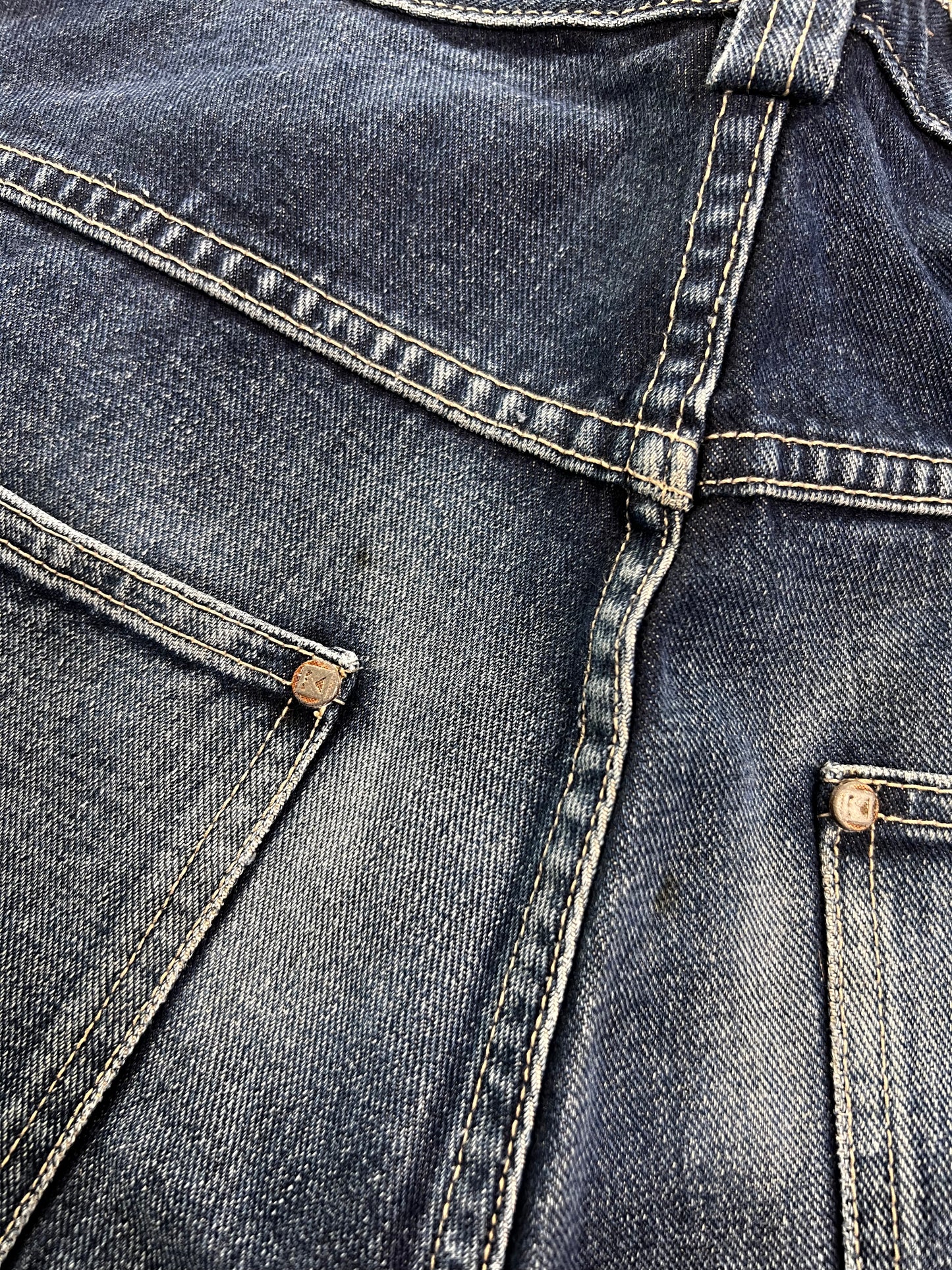 Nahaufnahme der Rückseite der Karl Kani Baggy Jeans von ZAZA Resell (W30 x L30). Sie zeigt zwei Taschen mit sichtbaren Nähten, Metallnieten und verblasster Denim-Textur – ideal, um Merkmale wie Bundweite und Beinöffnung hervorzuheben.
