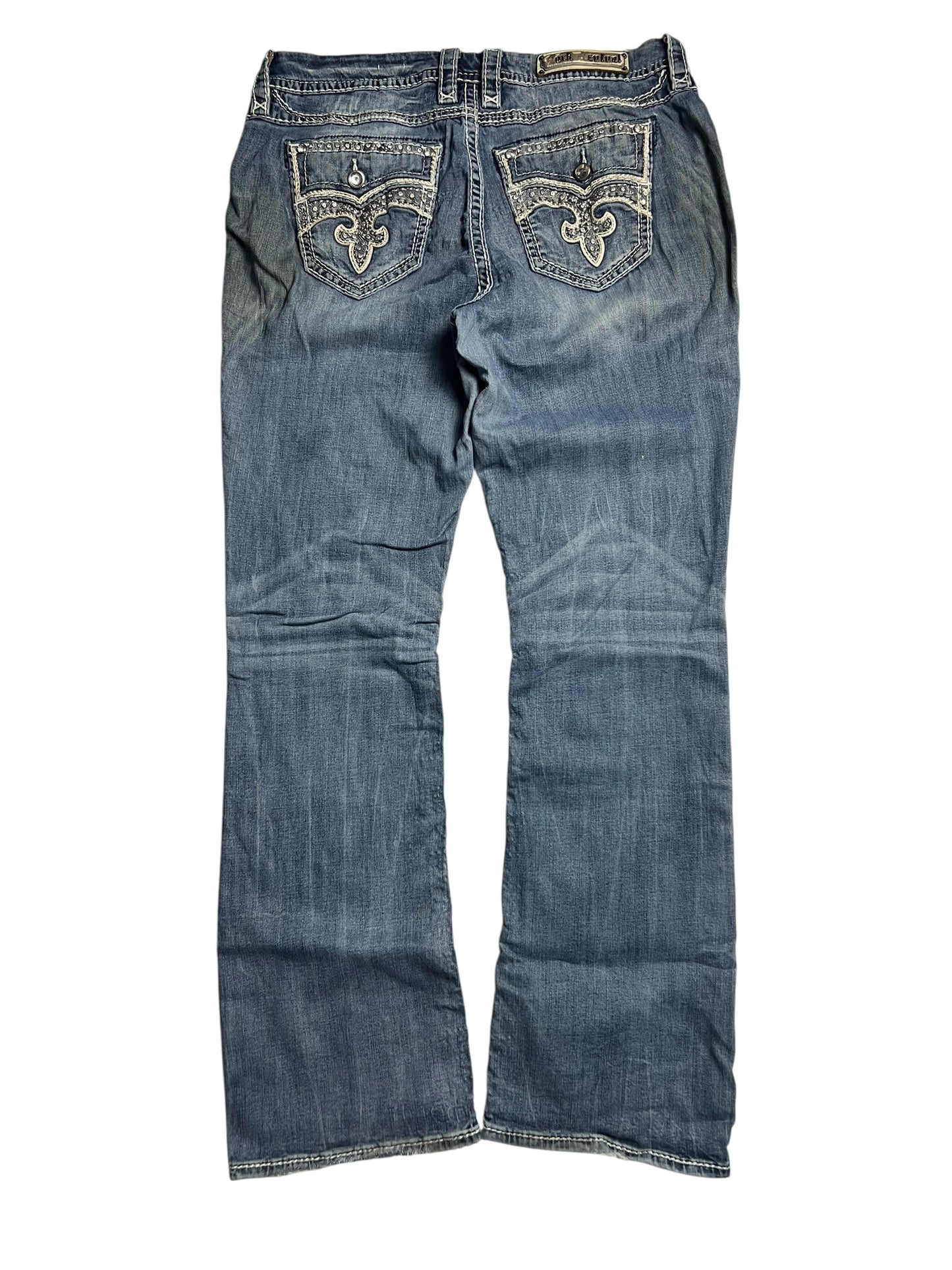 Die Rock Revival Mid Rise Boot Jeans von ZAZA resell, Größe 32 (XL), verfügt über dekorative Nähte an den Gesäßtaschen, eine leicht verblasste blaue Waschung und Bundweite 46 für eine bequeme Passform, hier von hinten.