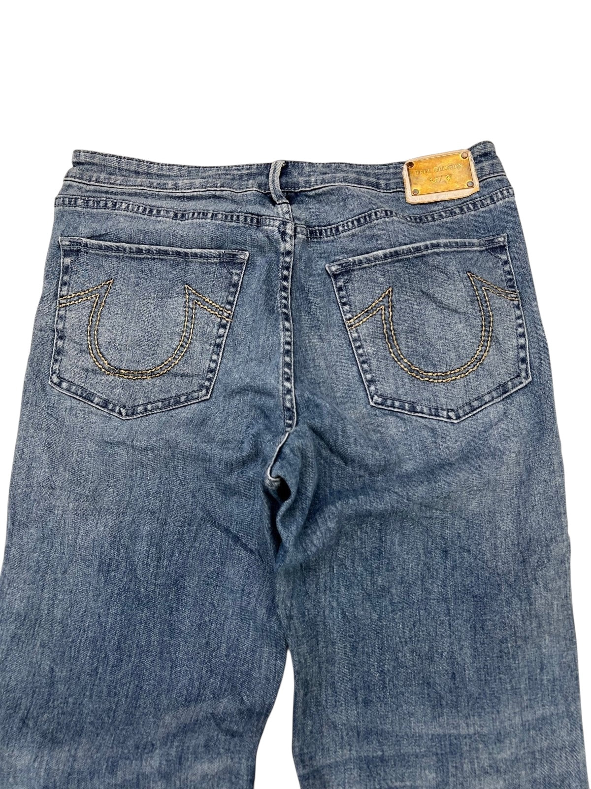 True Religion x Manchester United Mid Rise Flare Jeans von ZAZA Resell, W34 x L30, von hinten gezeigt, mit zwei hufeisenförmigen Taschen und einem hellbraunen Lederpatch. Seltenes Modell in 9/10 Zustand – Maße beachten.