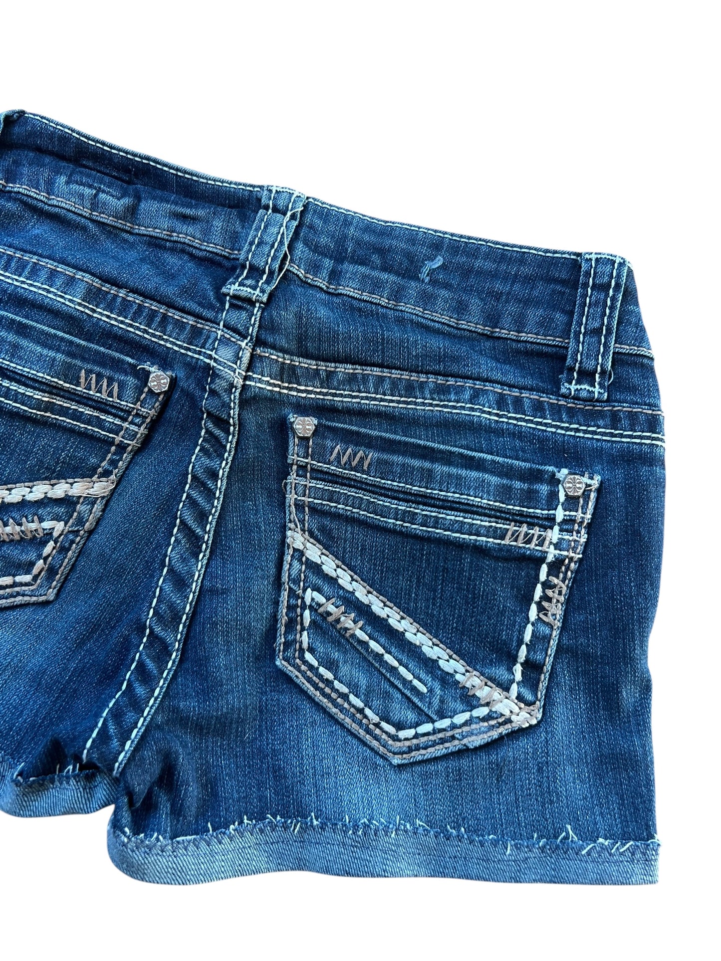 Ein Paar LA idol USA Shorts | XS von ZAZA resell in Bundweite 32, aus blauem Denim mit ausgefransten Säumen und Ziernähten an den Gesäßtaschen, abgebildet auf weißem Hintergrund.