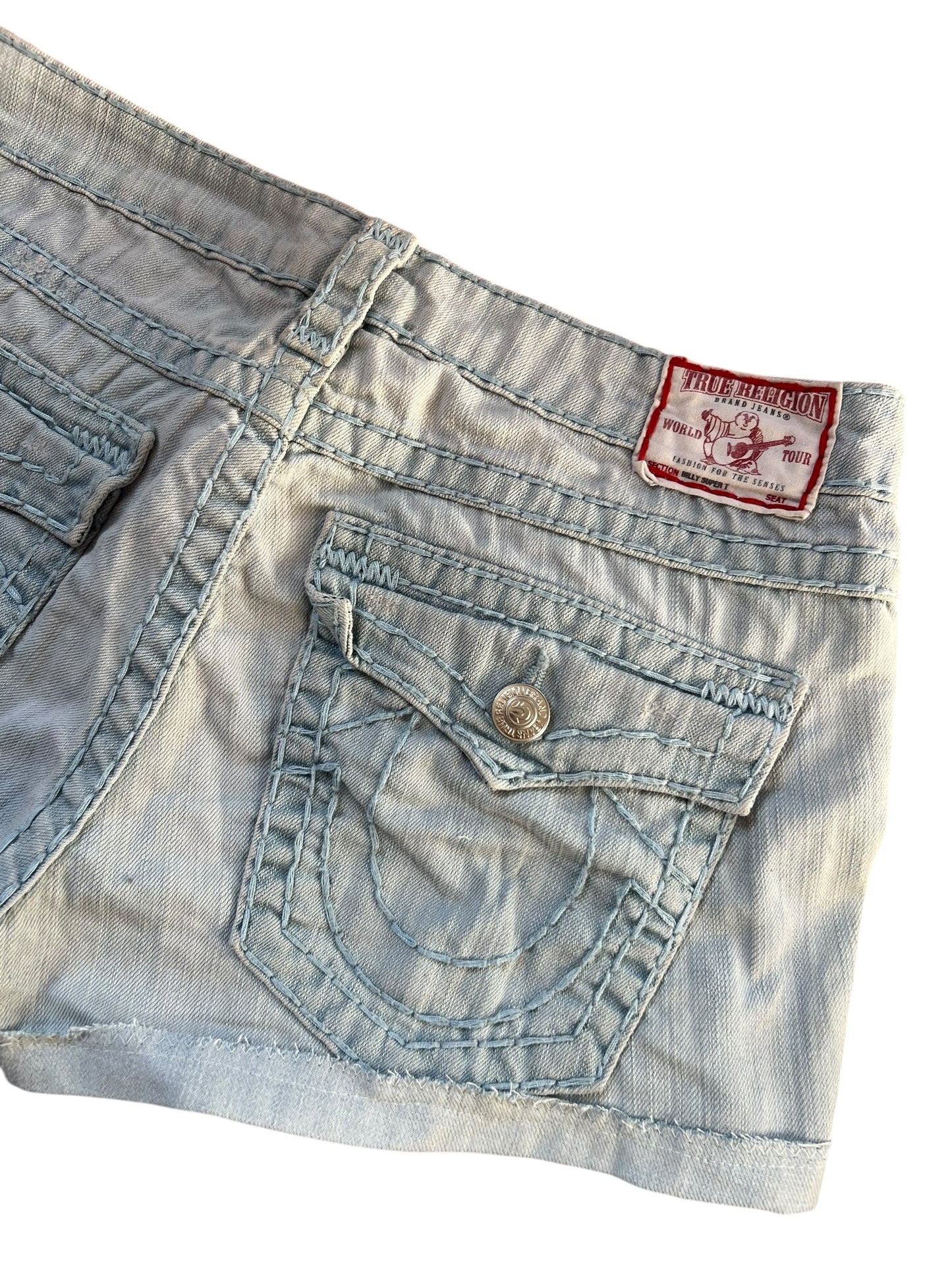 Eine Nahaufnahme der True Religion Shorts | 30 (M) von ZAZA resell zeigt eine Gesäßtasche mit Ziernähten, einen Metallknopf und ein rotes Markenetikett über der Tasche. Maße in Zentimetern verfügbar. Weißer Hintergrund.