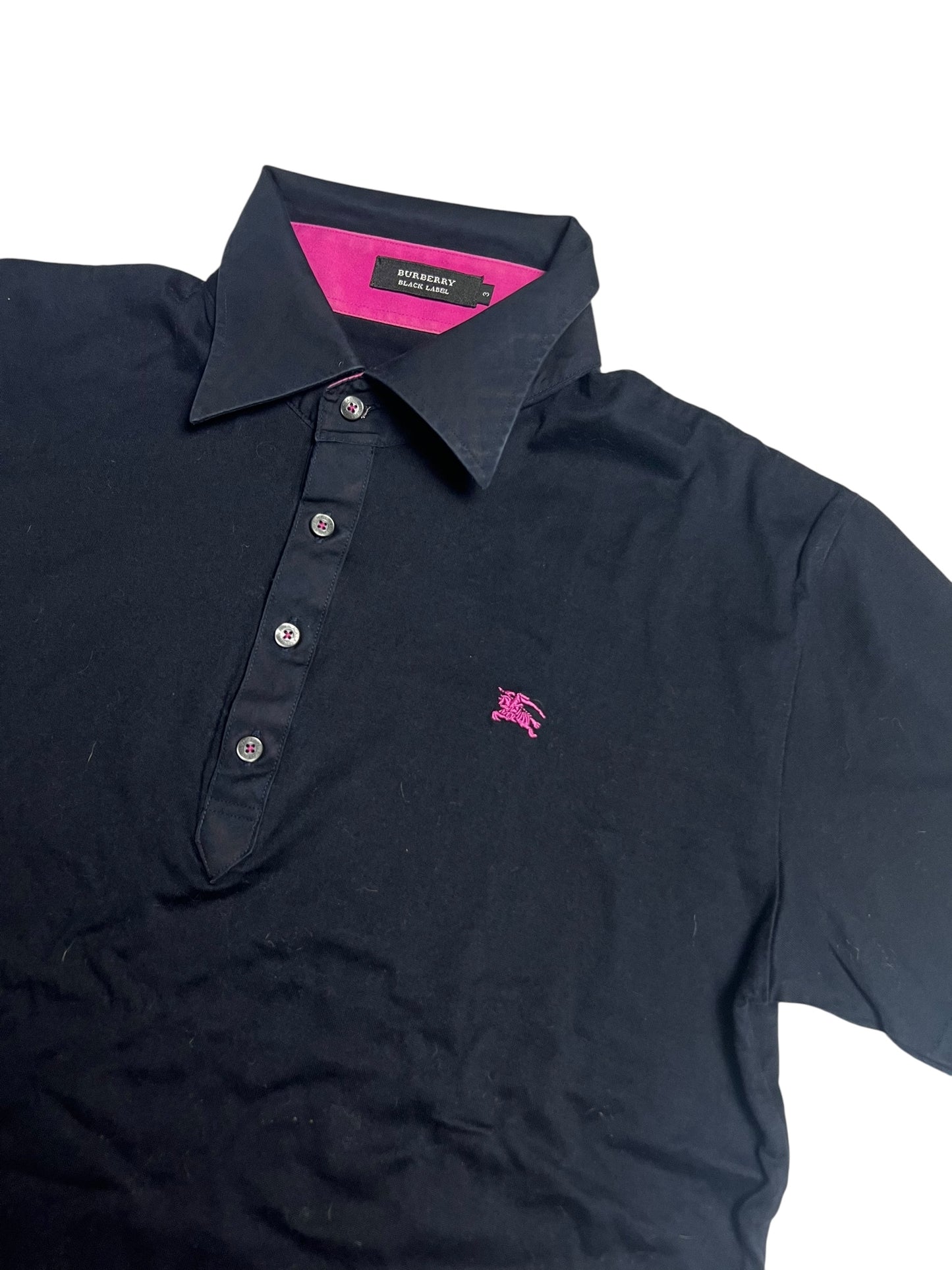 Ein schwarzes Burberry Polo Shirt | M von ZAZA resell mit rosa gesticktem Logo, rosa Knopfleiste, und rosa Innenkragen in sehr gutem Zustand. Maße und Labelgröße in der Artikelbeschreibung. Flach auf weißem Hintergrund fotografiert.