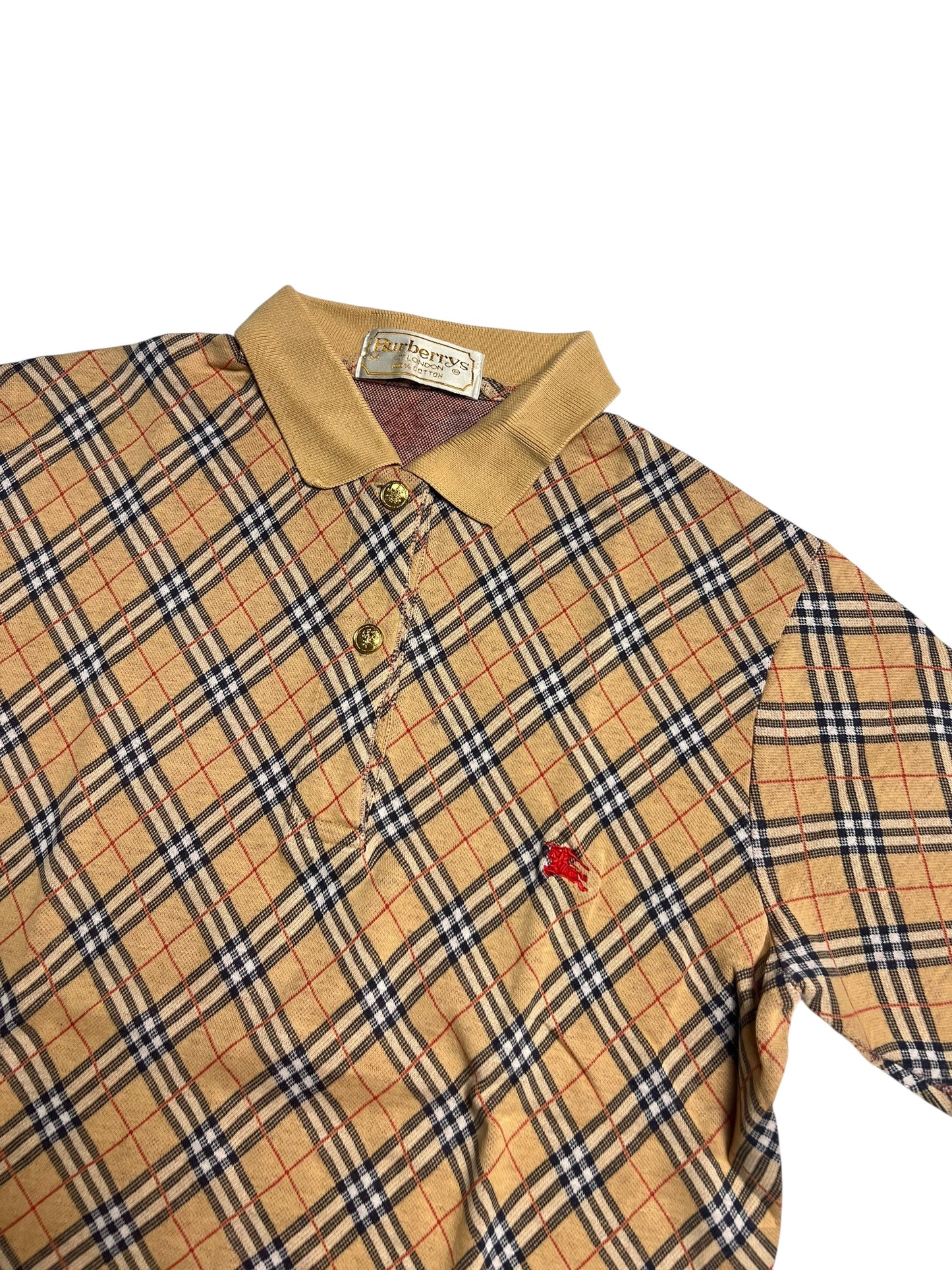 Burberry Polo Shirt | M von ZAZA wiederverkaufen: Mit beigem, schwarzem und rotem Plaid, beigem Kragen, drei Knöpfen und kleinem, rot gesticktem Brustlogo. Zustand 9 von 10. Maße auf Anfrage. Angezeigt auf weißem Hintergrund.