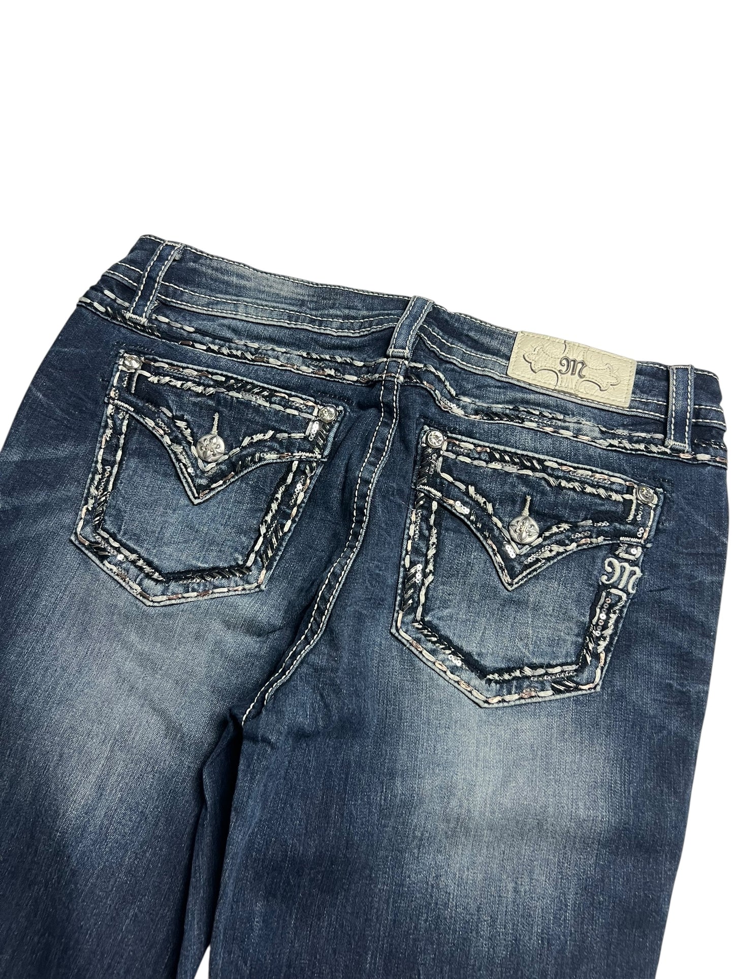 Miss Me Low Rise Boot Jeans von ZAZA resell in Größe 32 (L), dunkelblau mit ausgeblichenen Details, dekorativ aufgenähten Gesäßtaschen mit Knopfleiste, einem beigen Markenlabel über der rechten Tasche und präziser Bundweite für Komfort.