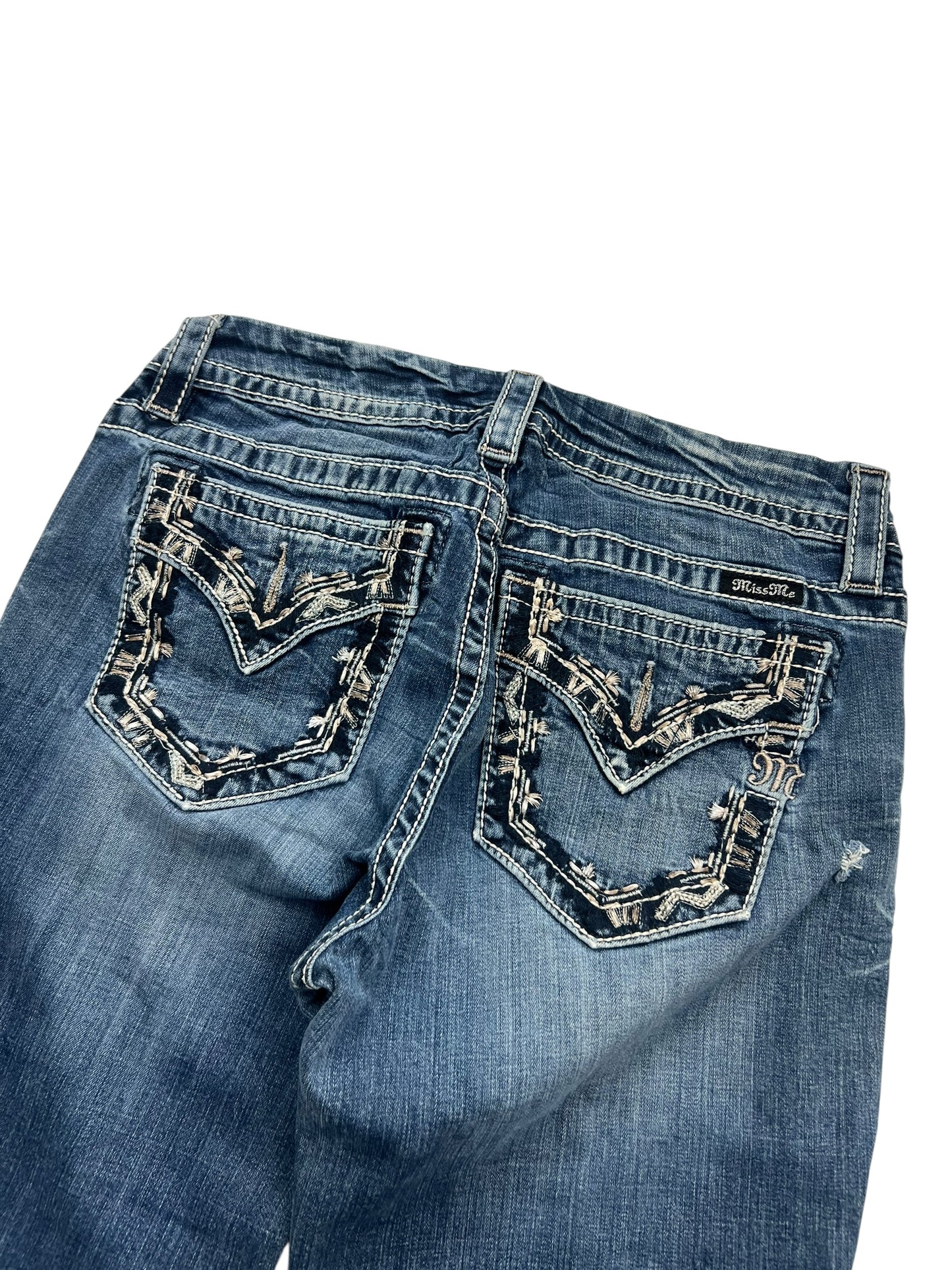 Die ZAZA resell Miss Me Mid Rise Curvy Boot Jeans in Größe 28 (M) ist aus blauem Denim mit Ziernähten, aufgestickten Gesäßtaschen und einem Schnitt für großen Hintern, der flach mit Bund und Oberschenkeln gezeigt wird.