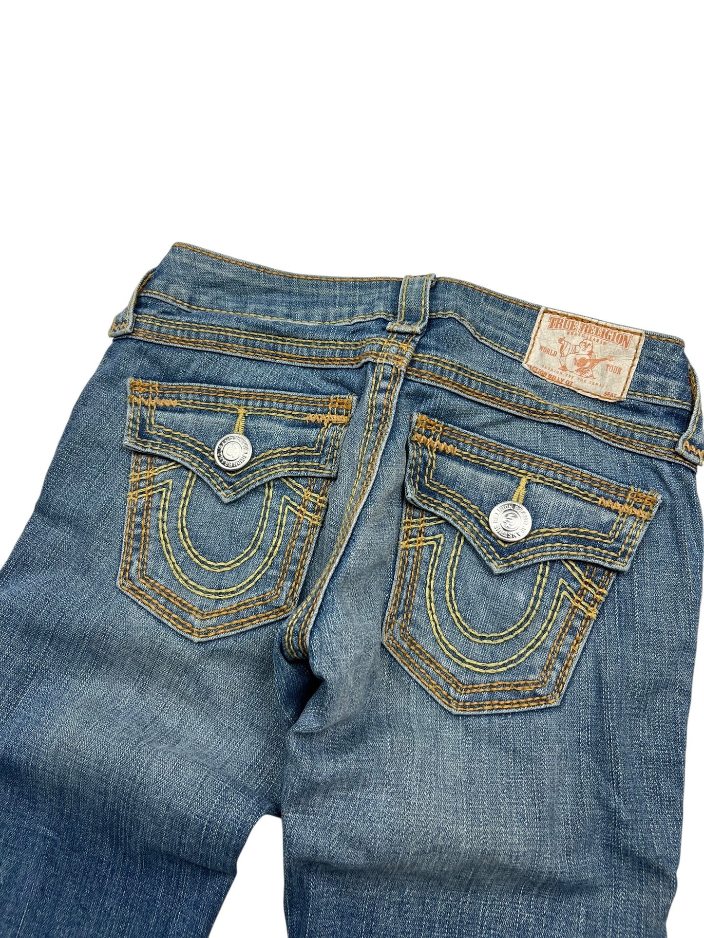 Ein Paar blaue True Religion Billy QT - Low Rise Straight Jeans (Größe 24 S) von ZAZA resell, gezeigt von hinten mit charakteristischen gelben Nähten, silbernen Knopfpattentaschen und einem Marken-Lederaufnäher-ultra seltener Fund mit detaillierter Bundweite.