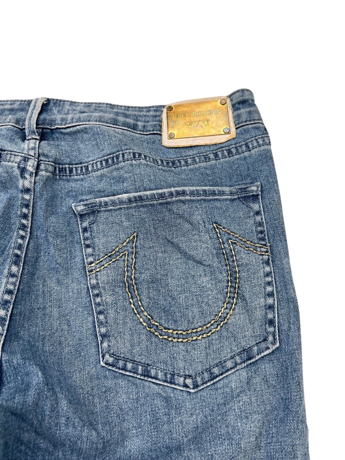 Nahaufnahme der True Religion x Manchester United Mid Rise Flare Jeans (W34 x L30) von ZAZA Resell – mit einer Gesäßtasche mit einzigartiger Naht und einem goldenen rechteckigen Bundetikett. Zustand: 9/10, ideal für Sammler.