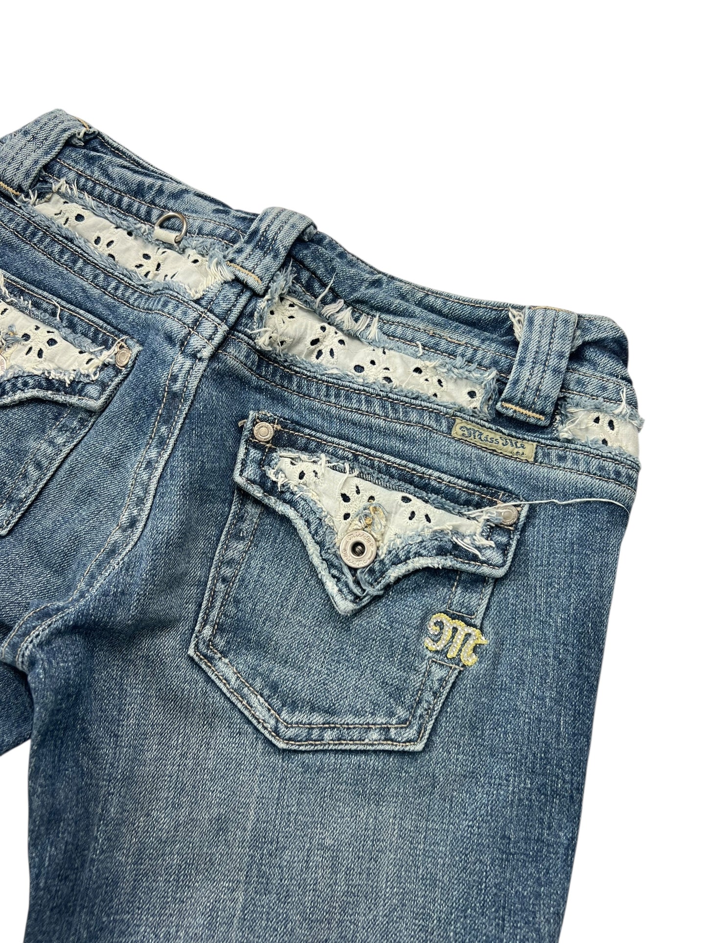 ZAZA verkauft „Miss Me Low Rise Boot“ (W26 x L31): Blaue Jeans mit verstellbarer Bundweite, Metallknopf, gelbem „mc“ auf der Gesäßtasche, bestickten Taschen und Spitzenbesatz-Akzenten an Bund und Kanten.