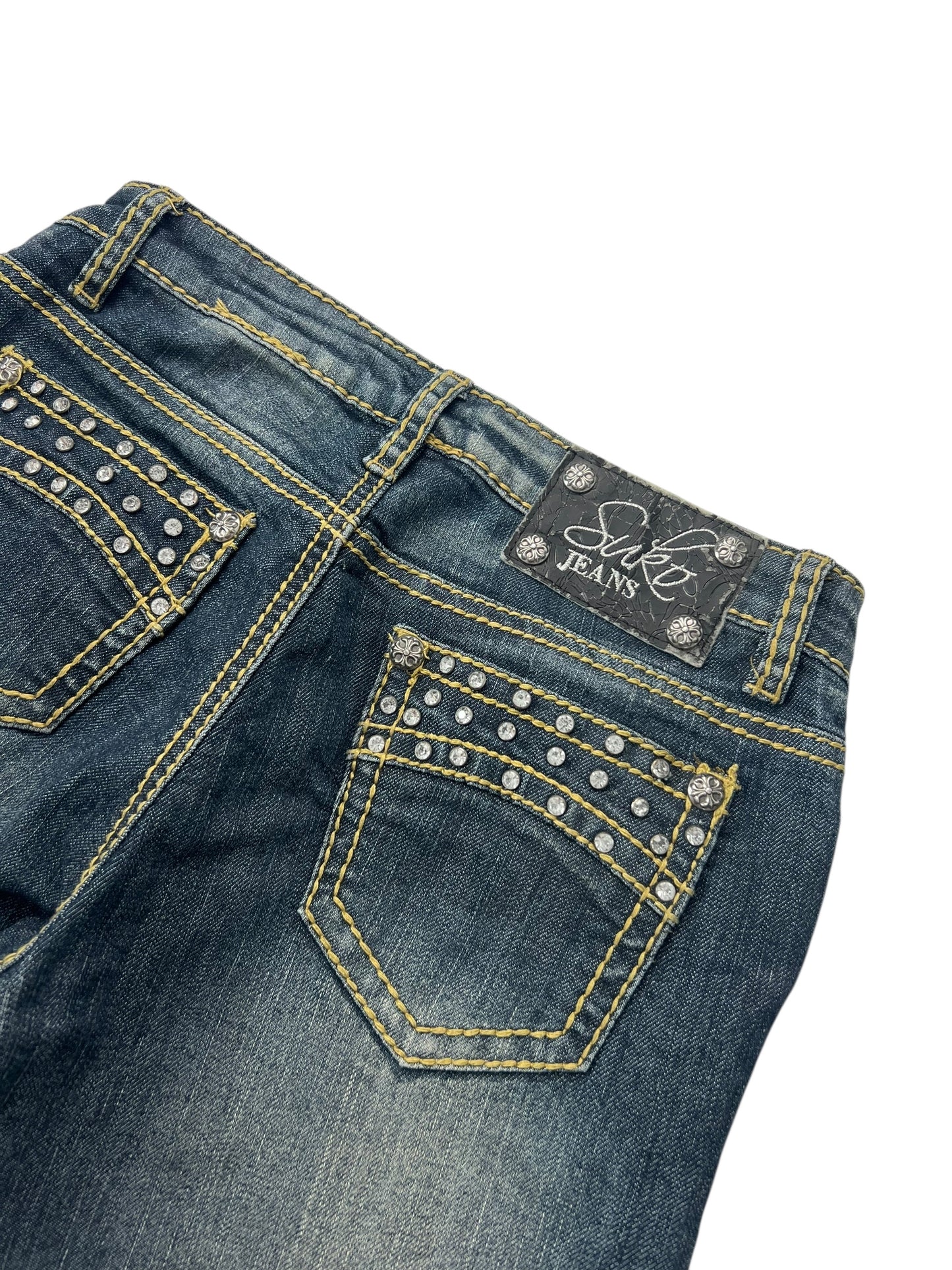 Der Suko Jeans Mid Rise Boot (W26 x L34) von ZAZA Resell aus dunkelblauem Denim verfügt über gelbe Nähte, mit Silbernieten besetzte Gesäßtaschen und ein schwarzes „Suki Jeans“-Patch-Etikett und bietet ein stilvolles Design und eine bequeme Bundweite für die perfekte Passform.