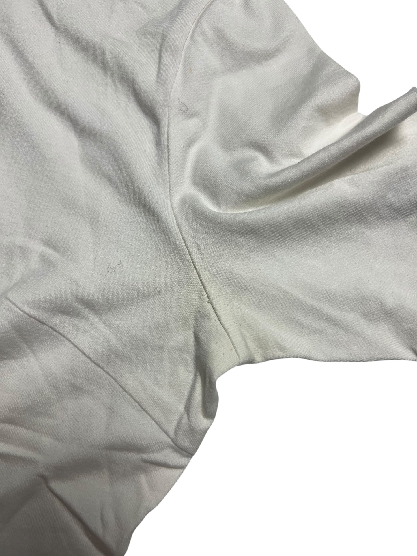Eine Nahaufnahme des Achselbereichs eines Burberry Polo Shirts (XS) von ZAZA resell, die leichte Falten und Flecken auf dem weißen Stoff vor weißem Hintergrund zeigt; Zustand: 8/10.