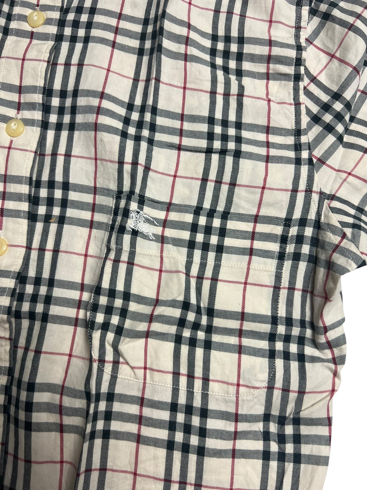 Eine Nahaufnahme eines Burberry Hemds in Größe S aus dem ZAZA-Wiederverkauf, mit schwarz-rot-weißem Karomuster, cremefarbenen Knöpfen, Zustandsbewertung 5/10 und einem kleinen gestickten Logo über der Brusttasche.