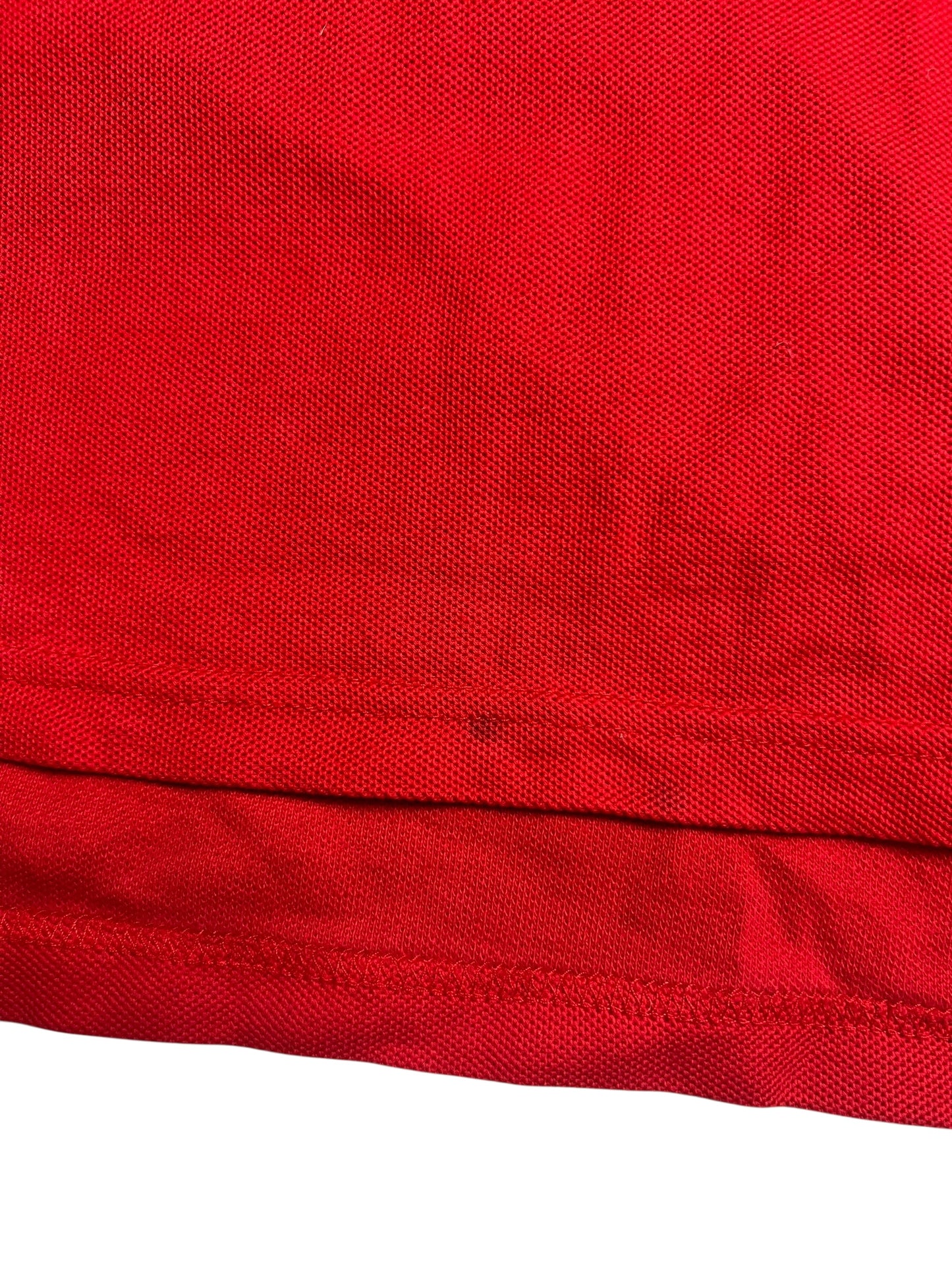 Nahaufnahme eines roten Burberry Polo Shirts (Größe M) von ZAZA resell, mit strukturiertem Netzmuster und gefaltetem Saum. Zustand: 9/10.