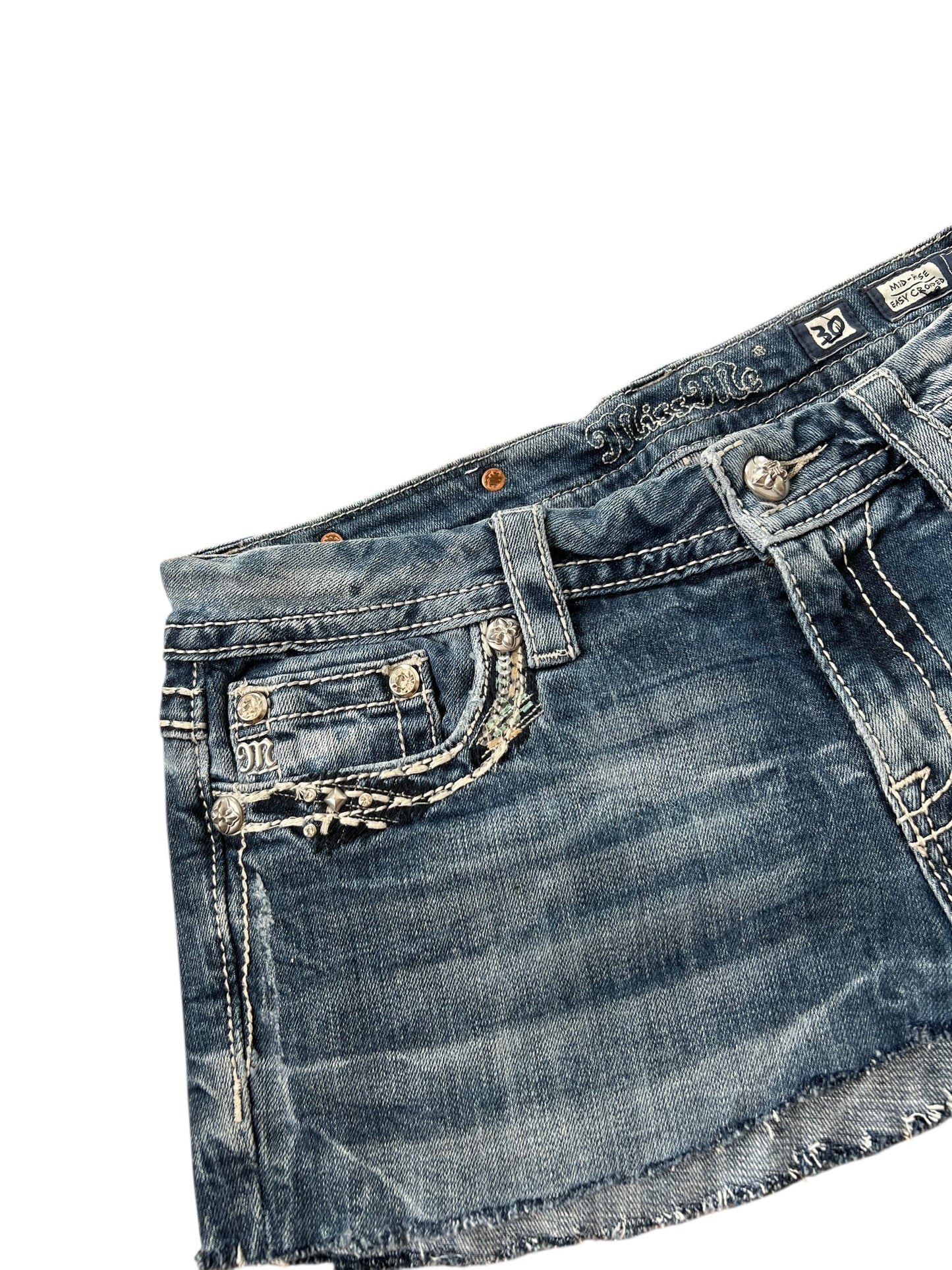 Miss Me Rock | W30 von ZAZA Resell: Jeans-Minirock mit ausgefranstem Saum, verwaschenem Blau, verzierten Fronttaschen, silbernen Knöpfen, Gürtelschlaufen und sichtbarem Markenlabel. Inklusive Bundweite und Außenbeinlänge; flach auf weißem Hintergrund abgebildet.