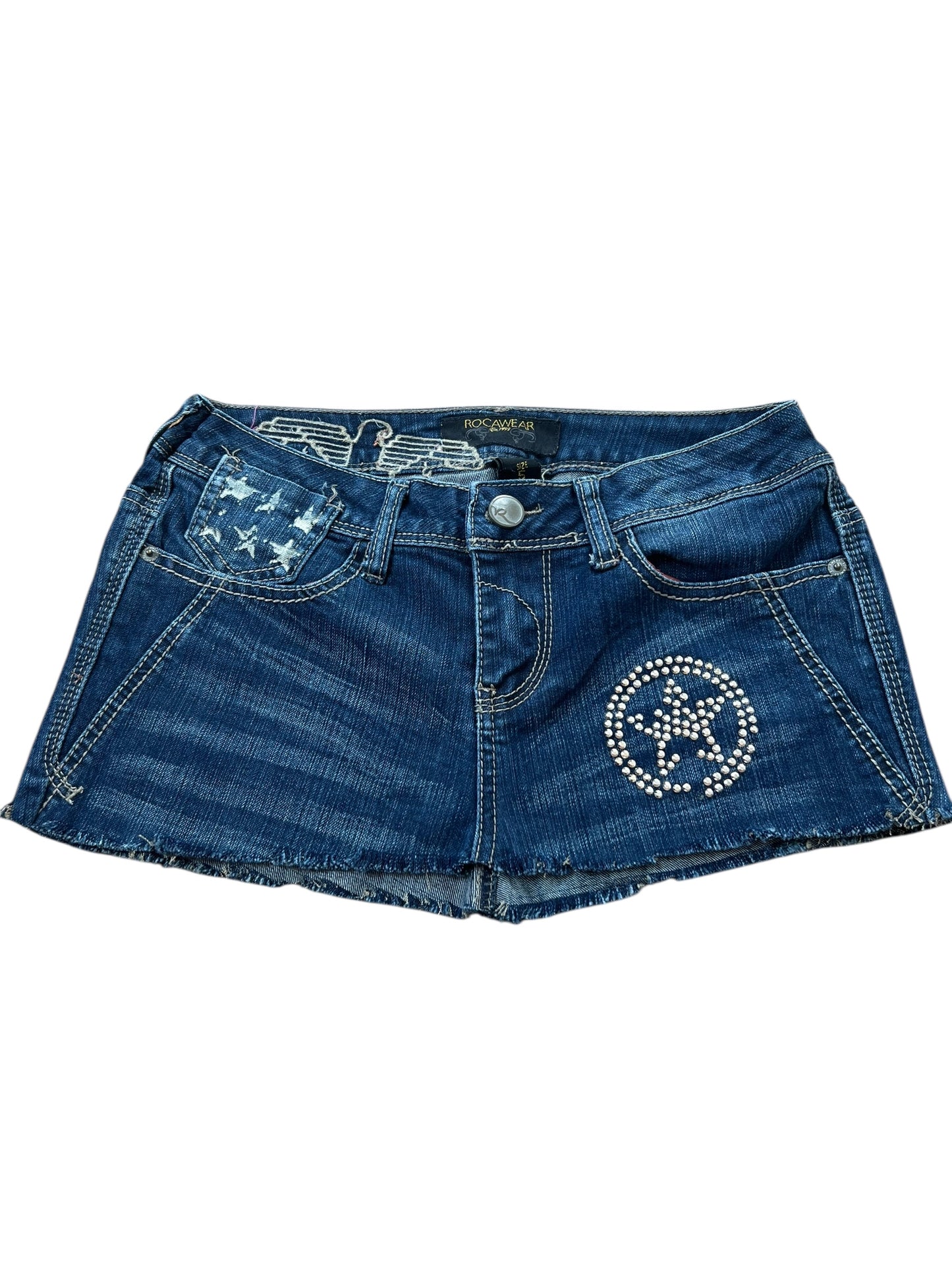 Der Rocawear Rock von ZAZA resell (W27) besticht durch Blue Denim, ausgefranste Säume, Strasssterne auf der linken Seite und eine kleine Fronttasche mit Sternenprint. Überprüfen Sie Bundweite und Außenbeinlänge, um Ihre ideale Passform zu finden.