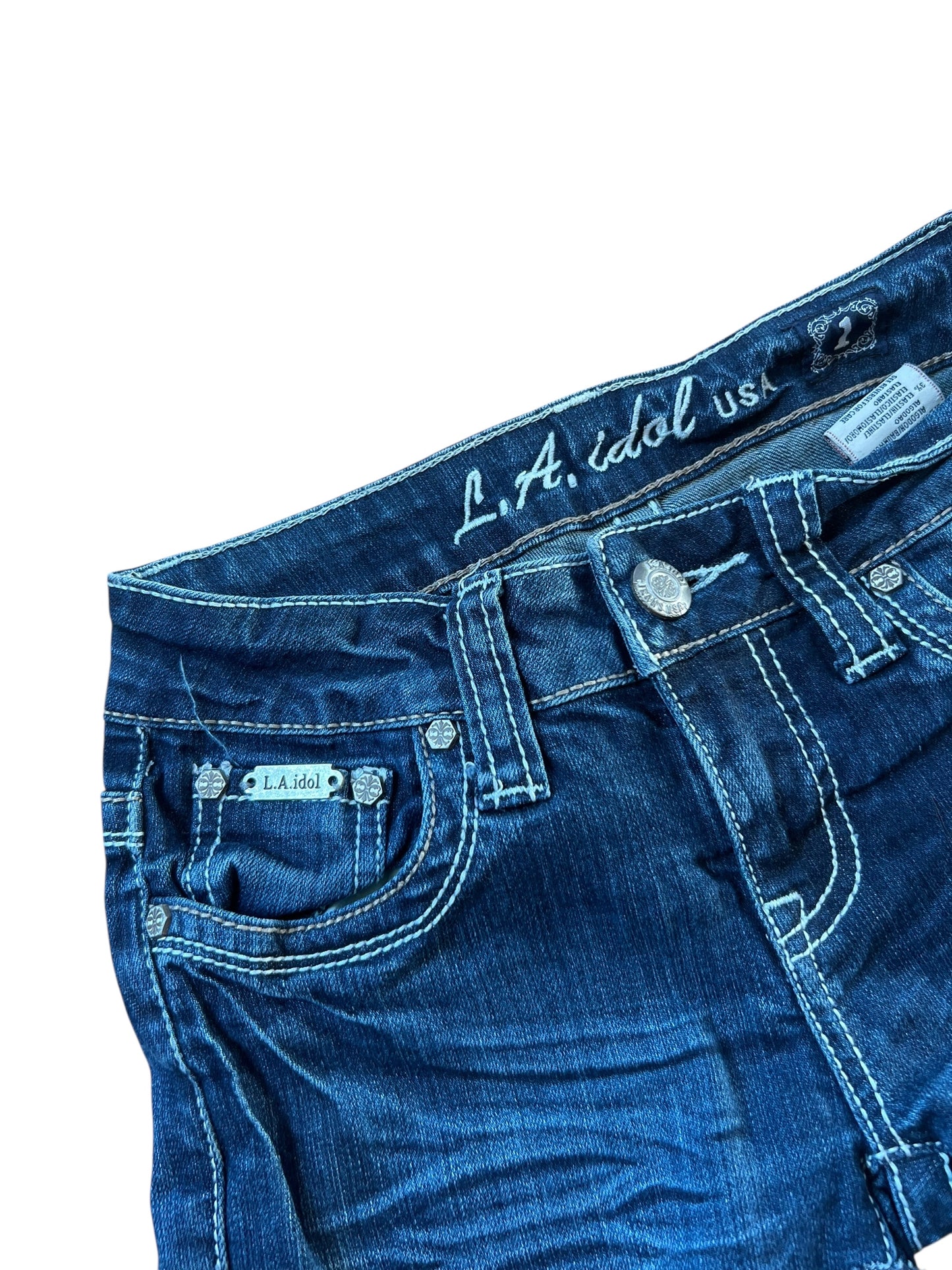 Eine Nahaufnahme des Bunds und des oberen Teils der blauen Denim LA idol USA Shorts | XS von ZAZA resell, mit weißen Nähten. Das innere Etikett zeigt LA idol USA und die Größe, mit einem kleinen LA idol Tag über der Vordertasche.