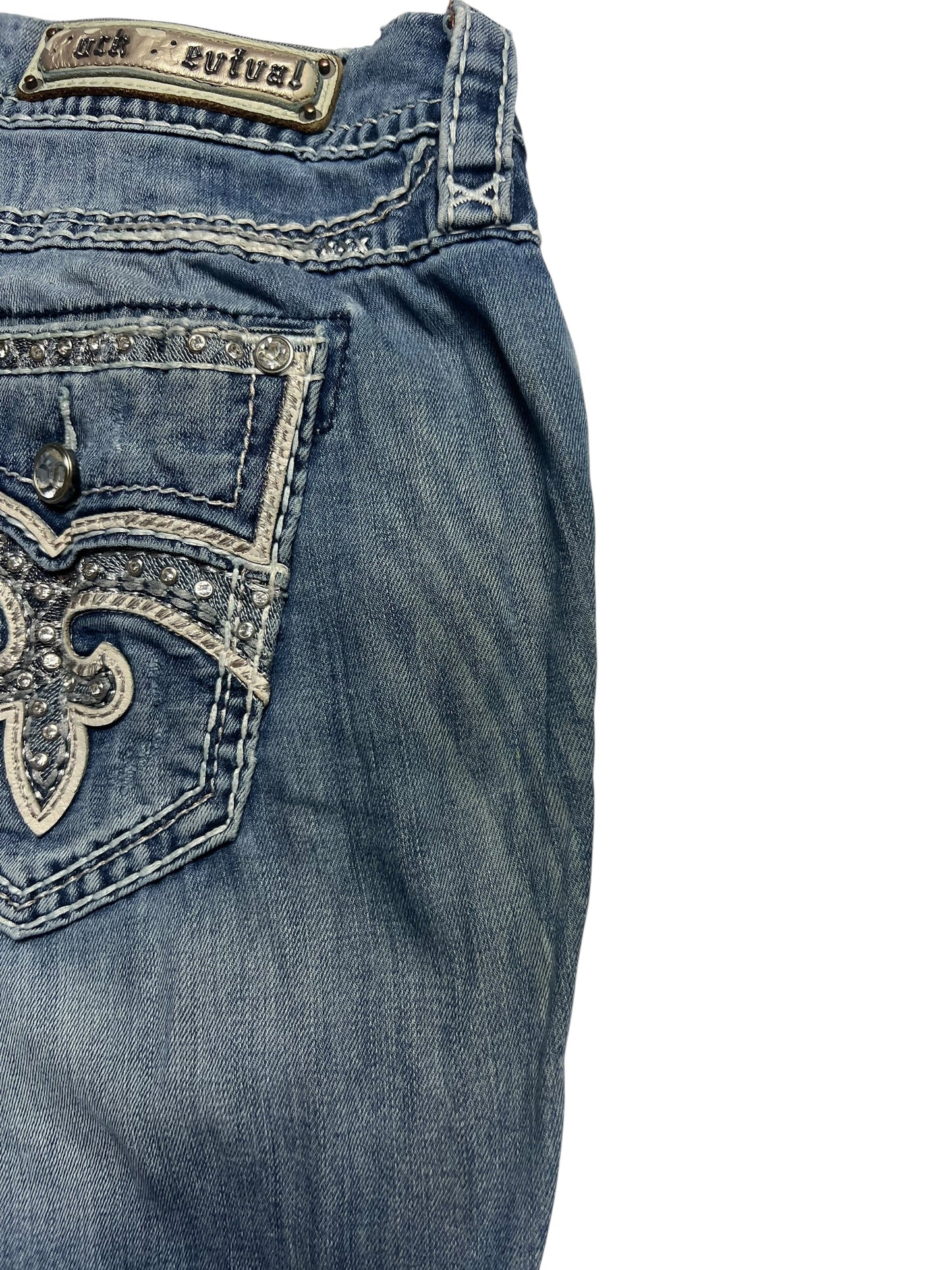 Rock Revival Mid Rise Boot Jeans (Größe 32/XL) von ZAZA resell in blauem Denim, mit Strassstein und bestickter Gesäßtasche, Rock Revival Metallbundlabel. Bundweite 46, Außenbeinlänge 110. Teilansicht auf weißem Hintergrund.