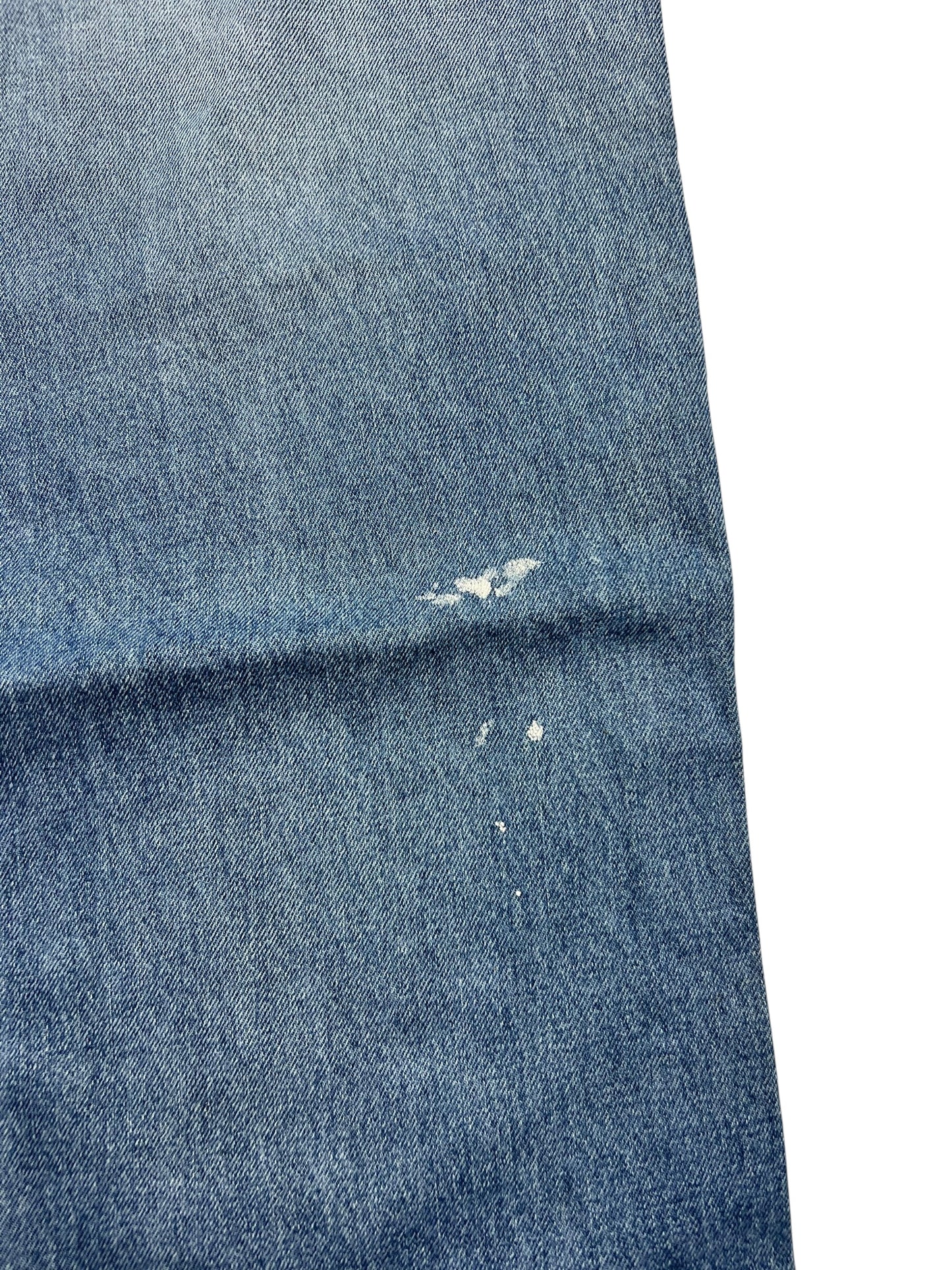 Ein blauer Denimschnitt mit abgenutzten Löchern und Distressed-Spots, gesetzt auf Weiß-Attribute wie Bundweite und Labelgröße machen die True Religion Straight | 34 (L) von ZAZA resell perfekt für eine detaillierte Bekleidungsanalyse.