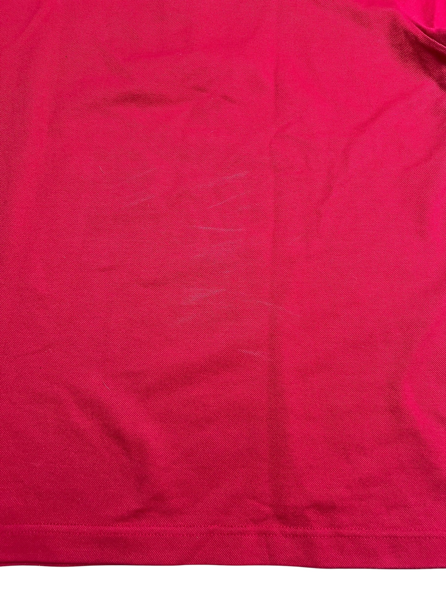 Eine Nahaufnahme eines Burberry Polo Shirts (L) von ZAZA resell zeigt roten Stoff mit schwachen weißen Kratzspuren und Falten; Zustand: 8/10.
