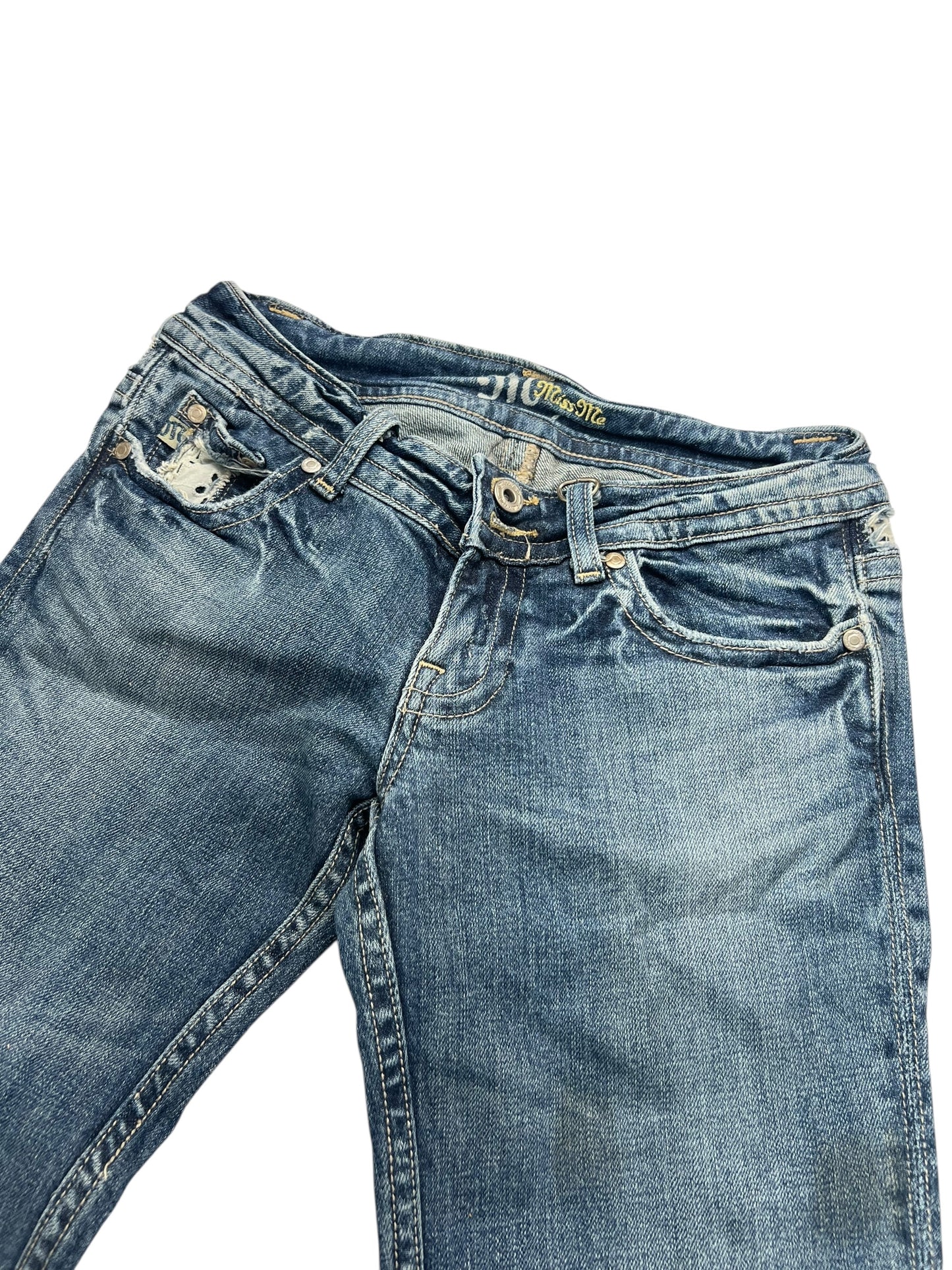 Miss Me Low Rise Boot Jeans (B26 x L31) von ZAZA Resell, blauer Denim mit leichtem Verblassen, Abnutzungserscheinungen und einem kleinen Riss in der Vordertasche. Außenbeinlänge und Bundweite verfügbar. Zustand: getragen, aber gut. Flach auf weißem Untergrund liegend.