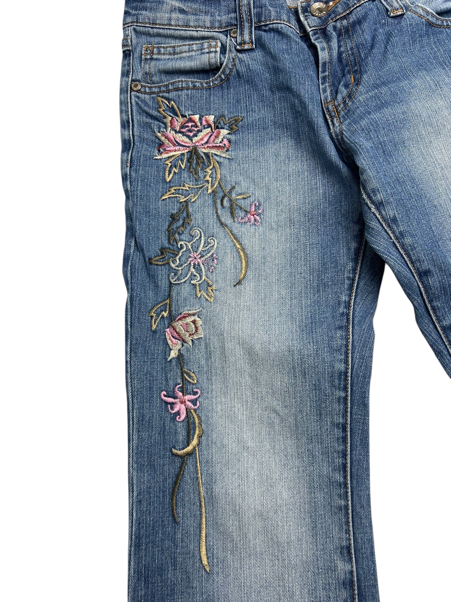 Die Y2K Low Rise Boot Jeans von ZAZA Resell (W26 x L30) bestehen aus blauem Denim mit gestickten rosa und lila Blumen mit grünen Blättern entlang des linken Beins und der Hüfte, einem verwaschenen Look, klassischen Taschennähten und einem bequemen Bund.