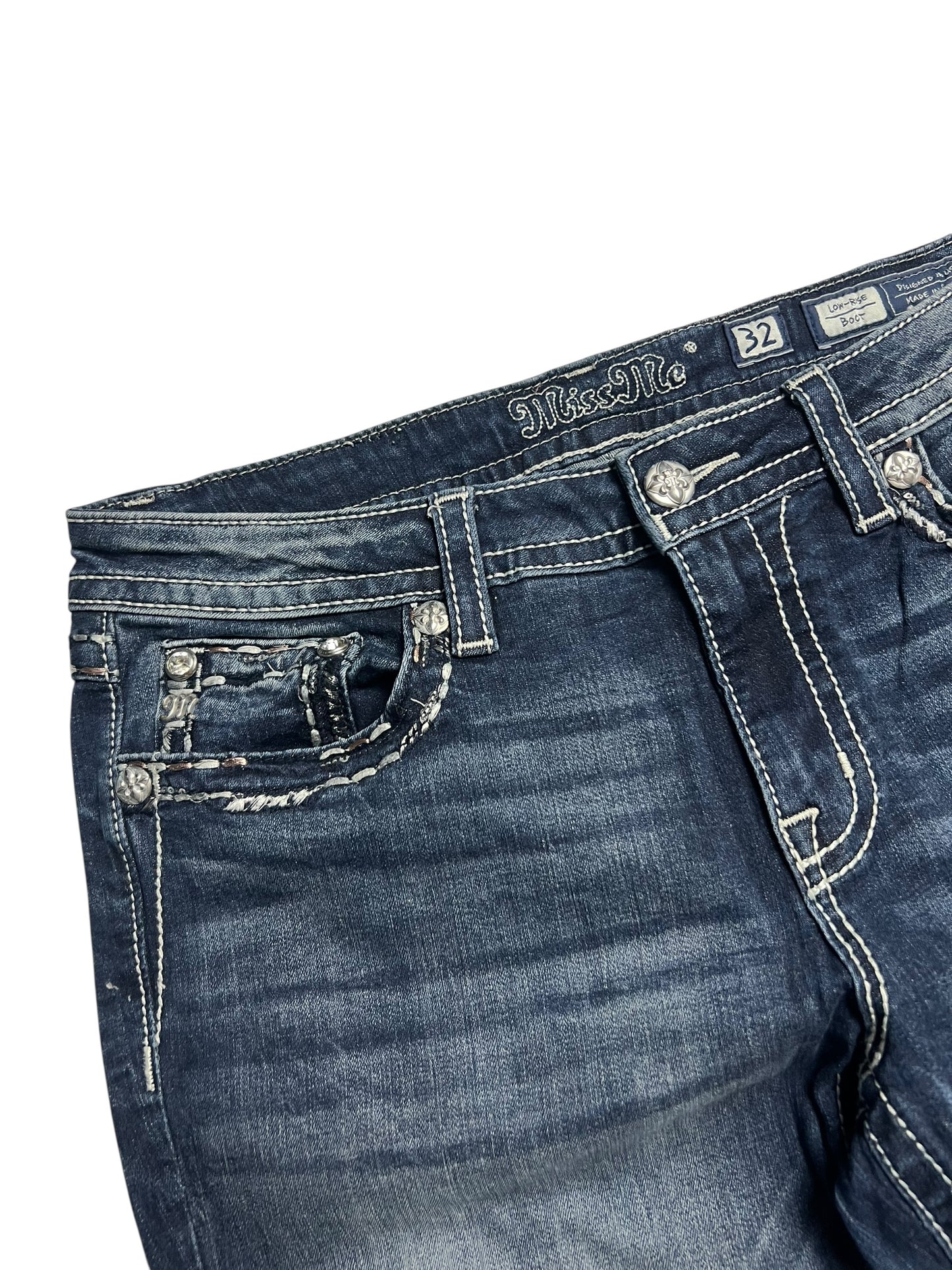 Nahaufnahme des Bundes und des oberen Teils der dunkelblauen Miss Me Low Rise Boot Jeans von ZAZA resell, Größe 32 (L), mit weißen Kontrastnähten, Gürtelschlaufen, einem Knopf und einer dekorativen Münztasche.