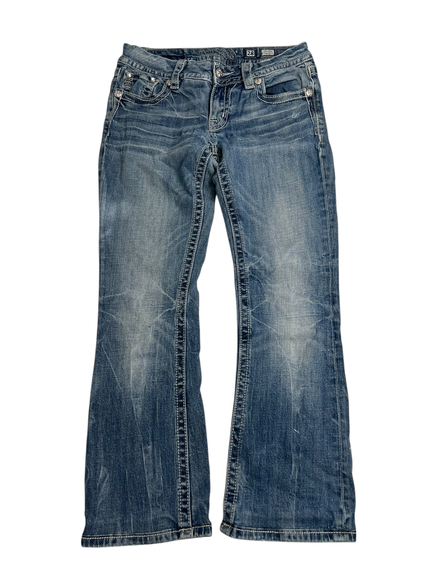 Ein Paar blaue, verwaschene Miss Me Mid Rise Boot Jeans (W28 x L26) von ZAZA Resell, flach auf weißem Hintergrund liegend, mit Vordertaschen, Gürtelschlaufen, sichtbaren Nähten und Details für perfekte Passform.