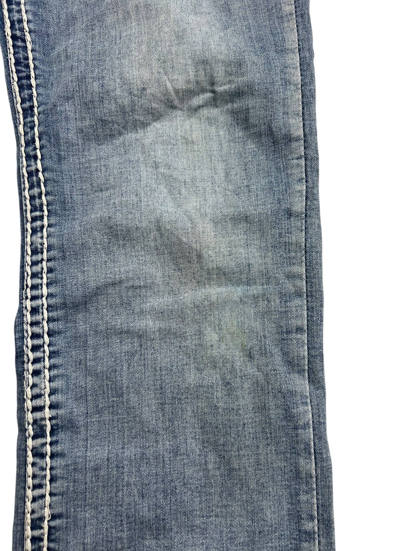 Eine Nahaufnahme der MyChristy Mid Rise Straight (W34 x L31) von ZAZA Resell zeigt die Seitennaht, die weißen Nähte, die Bügelfalten und die leichte Verfärbung des verblichenen blauen Denims, wodurch die Außenbeinlänge betont wird.