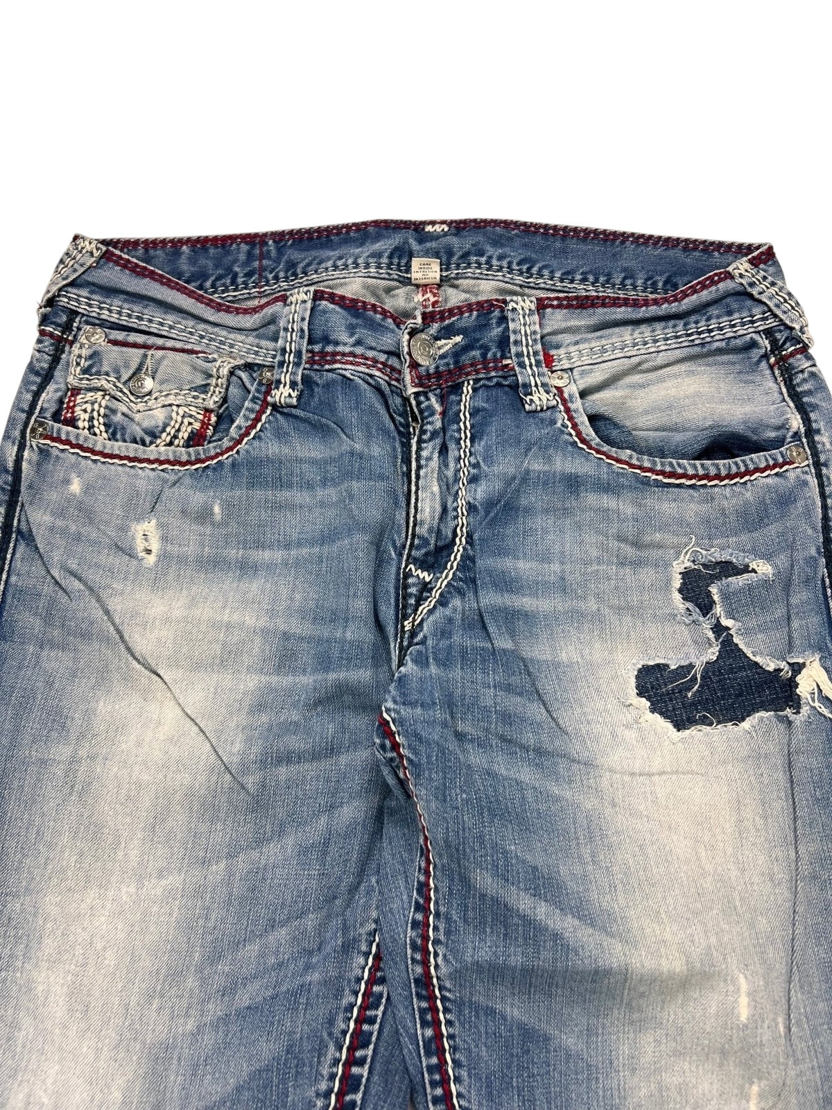 True Religion Mega T Straight Jeans von ZAZA resell in Größe 34 (M), blau mit roten Nähten, ausgeblichenen Stellen, zerrissenen Details und ausgefransten Patches an den Vordertaschen und Oberschenkeln.