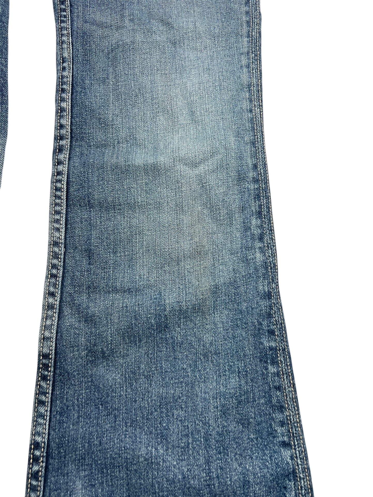 Eine Nahaufnahme des Unterschenkels der Miss Me Low Rise Boot Jeans (W26 x L31) von ZAZA Resell zeigt Denim-Struktur, Nähte und leichtes Ausbleichen, wobei Außenbeinlänge und Bundweite vor einem weißen Hintergrund hervorgehoben sind.