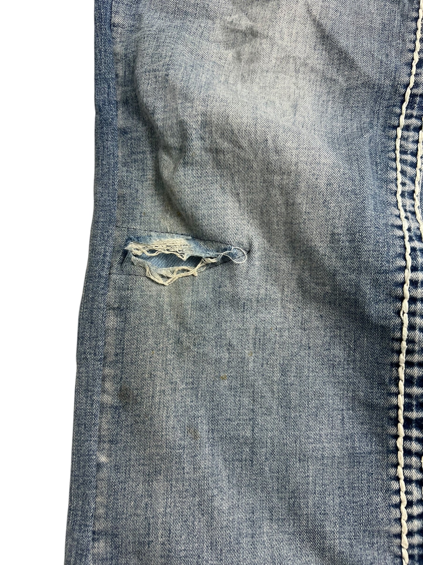 Eine Nahaufnahme von MyChristy Mid Rise Straight (B34 x L31) von ZAZA Resell in hellblauem Denim, die einen horizontalen Riss in der Nähe der Naht mit sichtbaren ausgefransten Kanten, Nähten, Webarten und Bundweite-Details zeigt.