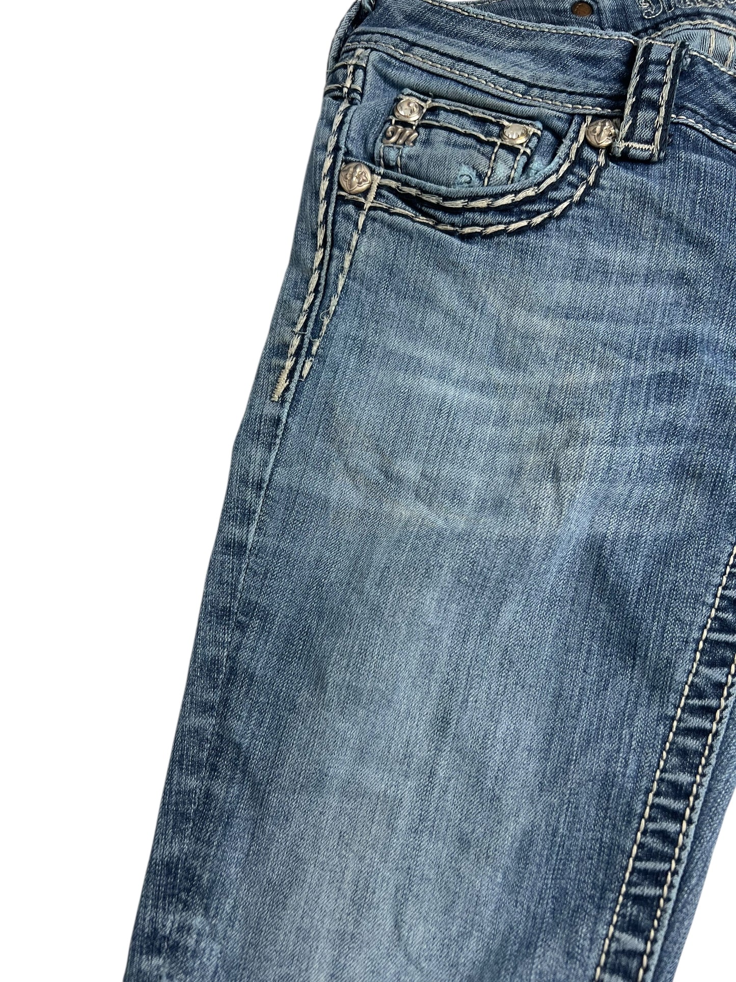 Eine Nahaufnahme der Miss Me Low Rise Boot Jeans (W25 x L30) von ZAZA Resell, die die Vordertasche, die Münztasche, die Gürtelschlaufe und die detaillierten weißen Nähte auf verwaschenem Denim für einen authentischen Look hervorhebt.