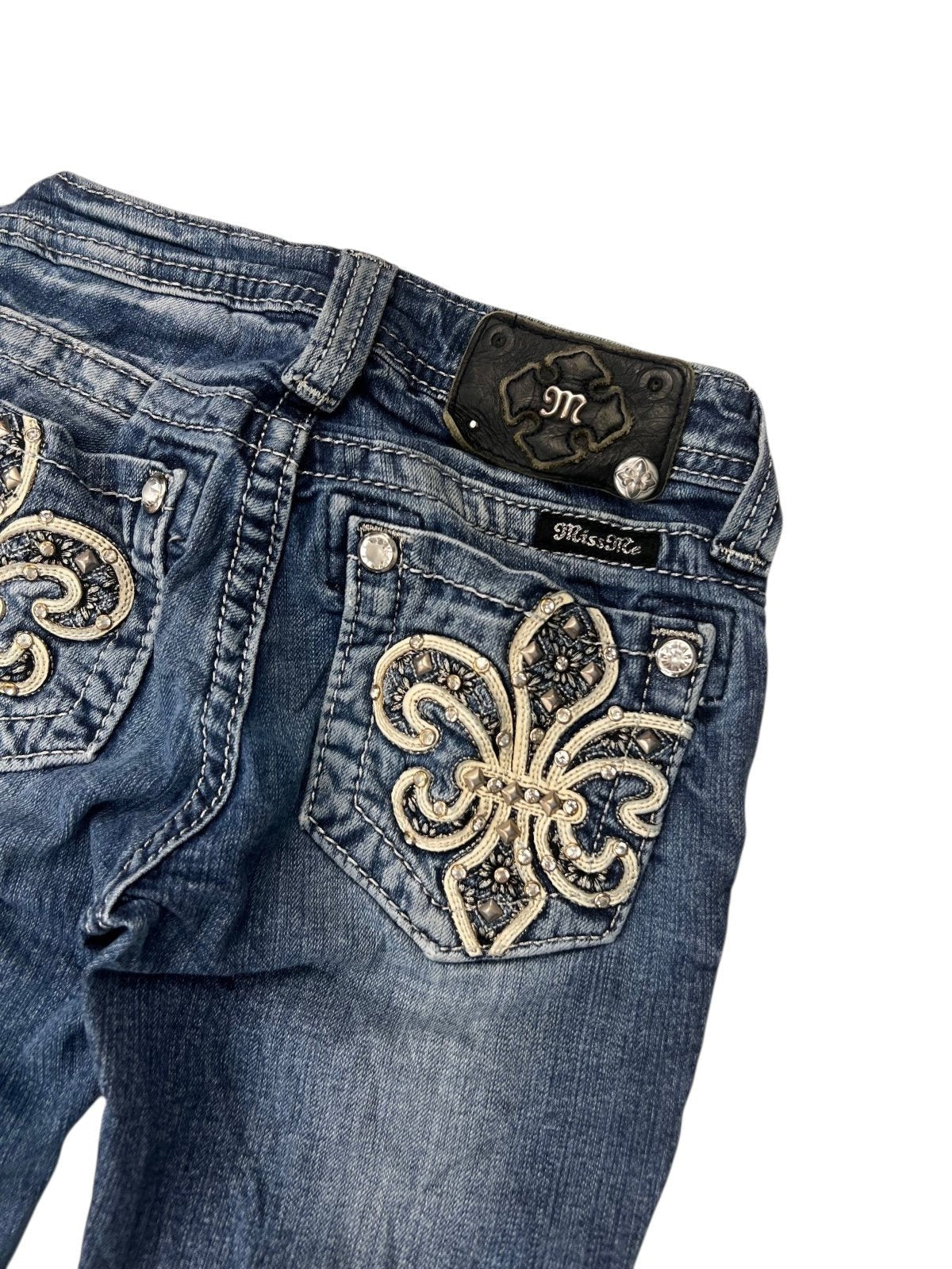 Miss Me Boot Jeans von ZAZA resell, Größe XXXS (Kindergröße): Blaues Denim, florale Stickereien mit Strass auf den Gesäßtaschen, silberne Knöpfe und schwarzes Markenlabel am Bund. Maße in cm auf Anfrage.
