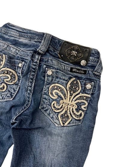 Miss Me Boot Jeans von ZAZA resell, Größe XXXS (Kindergröße): Blaues Denim, florale Stickereien mit Strass auf den Gesäßtaschen, silberne Knöpfe und schwarzes Markenlabel am Bund. Maße in cm auf Anfrage.