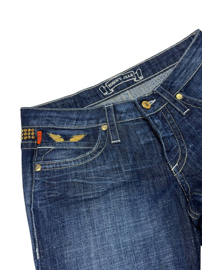Robin's Jean Low Rise Boot | 26 (S) von ZAZA resell: Dunkelblaue Denim-Jeans mit goldenen Nähten, Messingnieten, rotem Taschenanhänger auf der Vorderseite, goldenem Flügeldesign in der Nähe der Tasche, metallischen Nieten am Bund; Bundweite und Labelgröße auf Ronnie Jeans Label.