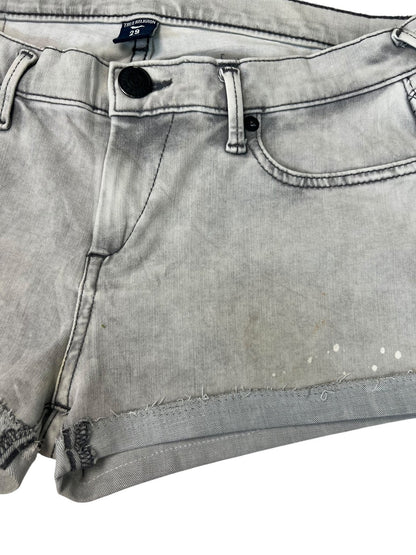 Eine Nahaufnahme der True Religion Shorts | 29 (M) von ZAZA resell aus hellgrauem Denim mit ausgefransten Säumen, schwarzem Knopf, Frontreißverschluss und schwachen Flecken sowie kleinen weißen Flecken am unteren Teil.