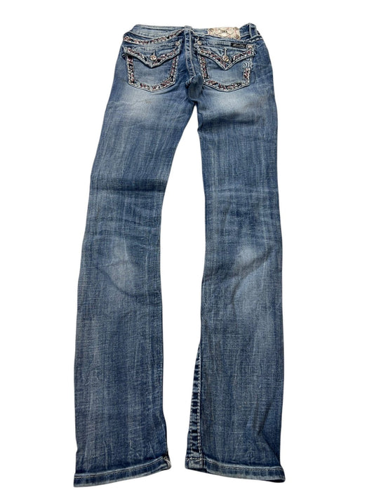 Eine blaue Bootcut-Jeans „Miss Me Low Rise Straight“ von ZAZA Resell mit verwaschenen Details und verzierten Gesäßtaschen, flach auf weißem Hintergrund abgebildet. Breite 25 x Länge 34. Labelgröße, Bundweite und Außenbeinlänge auf Anfrage erhältlich.