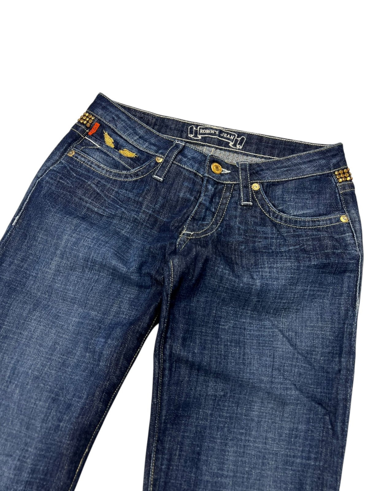Die Robin's Jean Low Rise Boot Jeans von ZAZA resell in Größe 26 (S) hat dunkelblauen Denim, gelbe Nähte, goldene Nieten und kleine dekorative Details in der Nähe der Vordertaschen; für eine genaue Größenbestimmung flach auf weißem Grund gelegt.