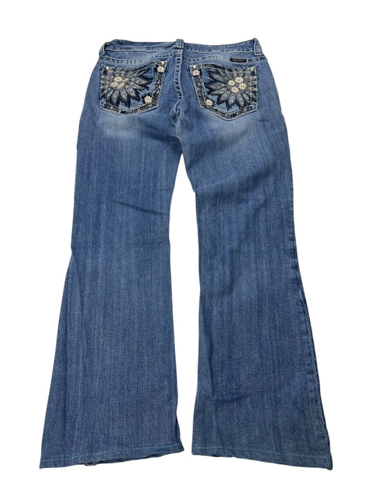 Miss Me Mid Rise Boot Jeans von ZAZA in den Größen W29 x L27, mit ausgestelltem Bein, verwaschenem Blue Denim und floraler Stickerei mit Pailletten auf den Gesäßtaschen. Flach mit der Rückseite nach oben gelegt, um Bundweite und Beinöffnung zu zeigen.