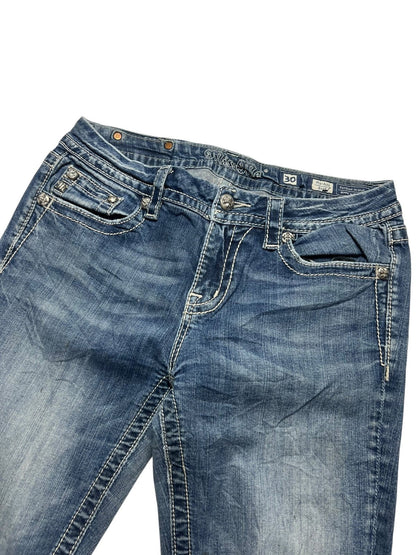 Die Miss Me Mid Rise Boot Jeans von ZAZA resell in Größe 30 (M) hat blauen Denim, weiße Kontrastnähte, Vordertaschen, Gürtelschlaufen und verblasste Oberschenkel. Die Jeans ist flach auf einem weißen Hintergrund abgebildet.