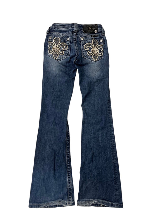Ein Paar Miss Me Boot Jeans von ZAZA resell in XXXS (Kindergröße), mit dekorativer Fleur-de-Lis-Stickerei auf den Gesäßtaschen, flach auf weißem Hintergrund.
