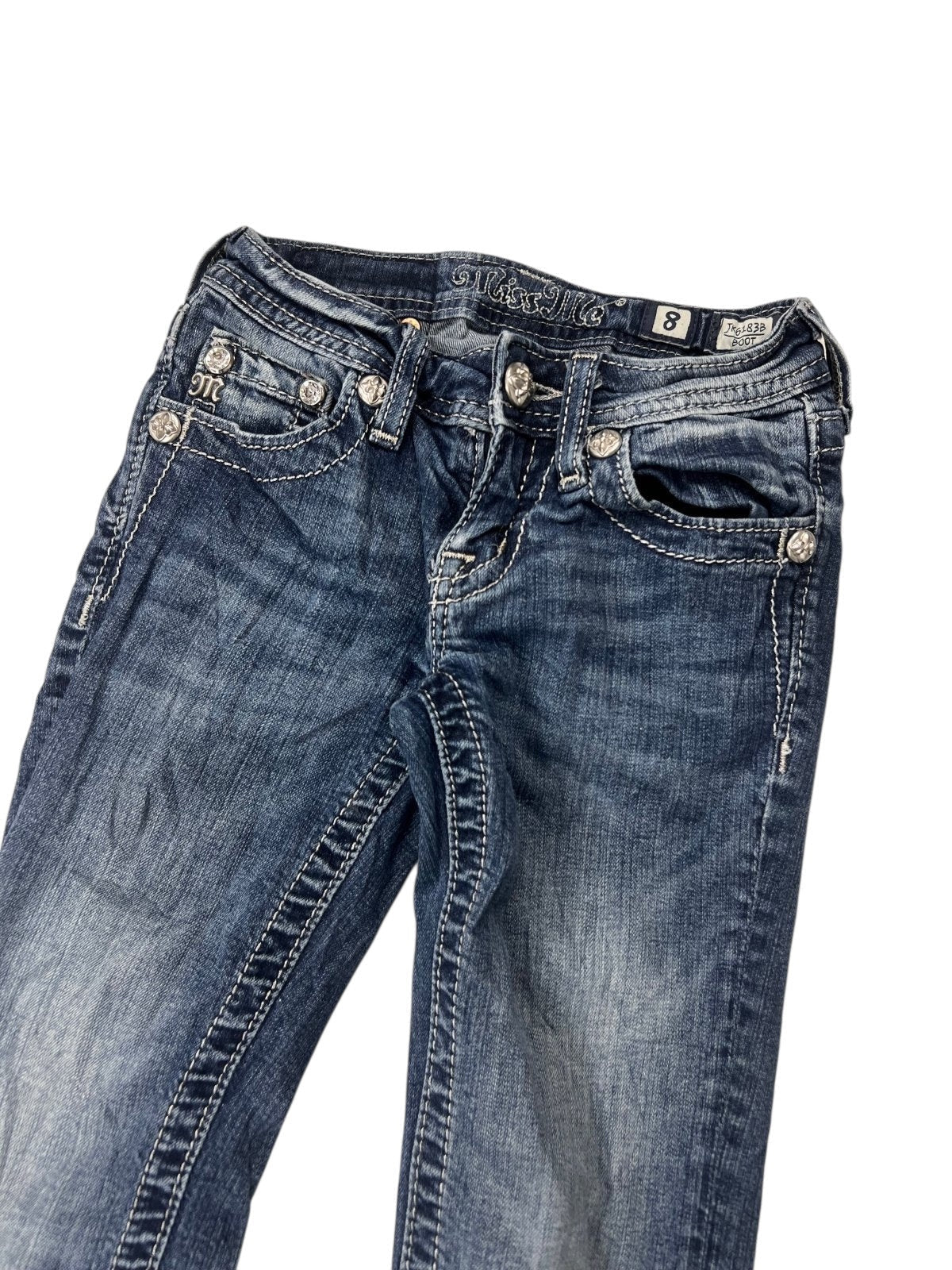 Ein Paar Miss Me Boot Jeans von ZAZA resell in Blau mit weißen Nähten und silbernen Zierknöpfen. Ausgestellt auf weißem Grund, mit einer Labelgröße 8 am Bund und einer Bundweite von 27,5 cm. Größe: XXXS (Kindergröße).
