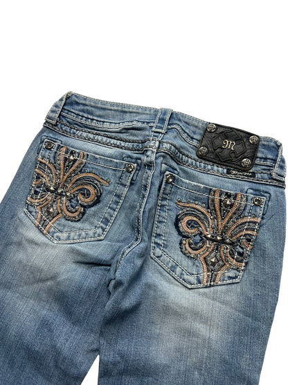 Die Miss Me Low Rise Boot-Jeans von ZAZA resell (Größe 26, S) hat einen verblassten blauen Denim, eine Fleur-de-Lis-Stickerei mit Strasssteinen auf den Gesäßtaschen und einen schwarzen Lederaufnäher mit einem M-Logo aus Metall. Überprüfen Sie Labelgröße und Bundweite für die perfekte Passform.